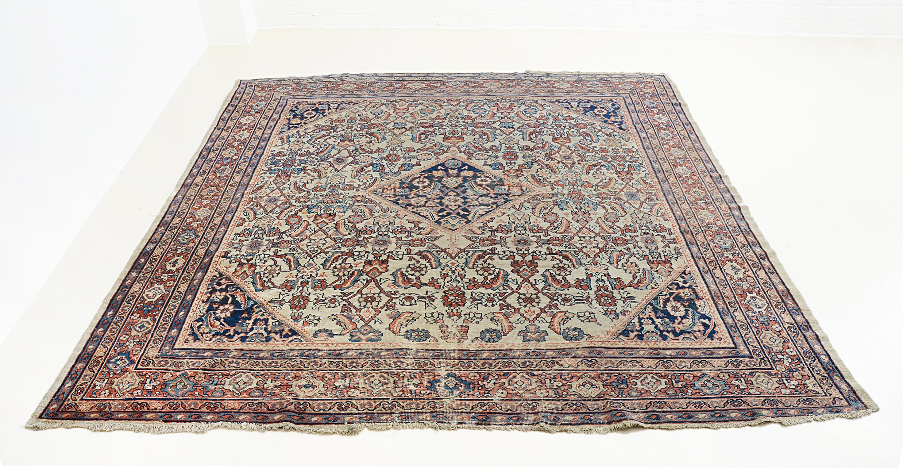 Large antique Mahal carpet with traditional Persian design and rich red tones
