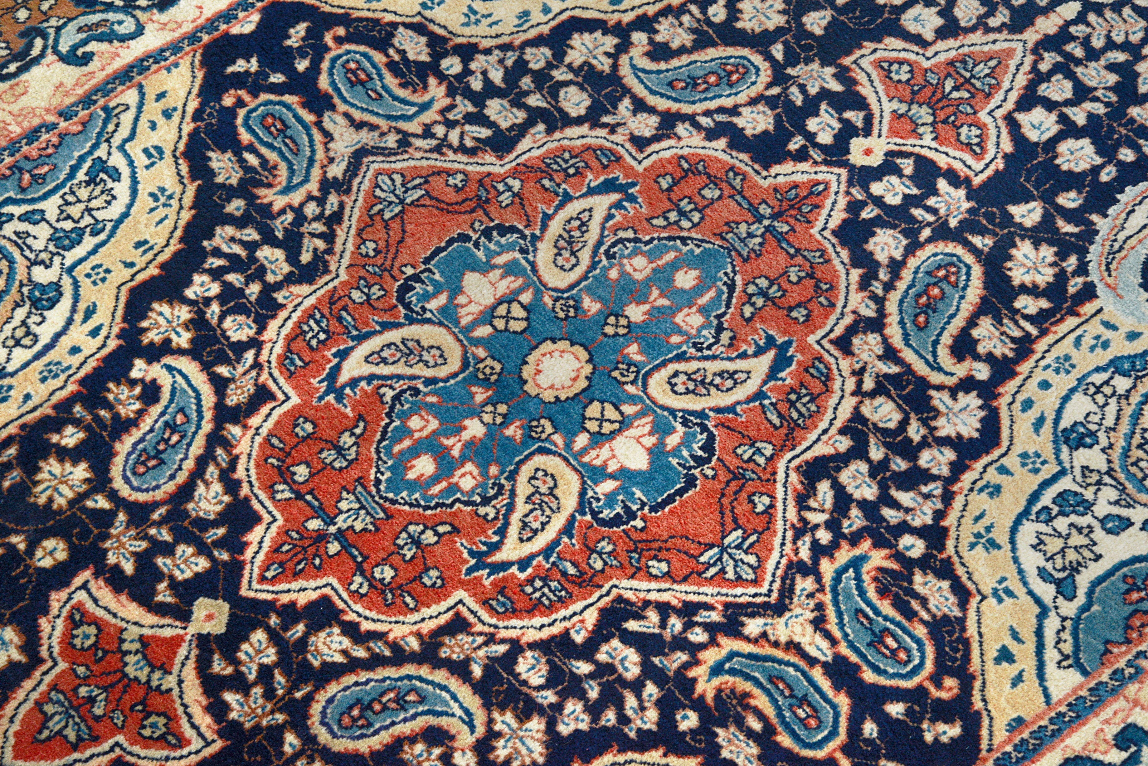 Close-up details of fine antique Persian Sarouk rug showing wool texture, motifs, and aged patina

