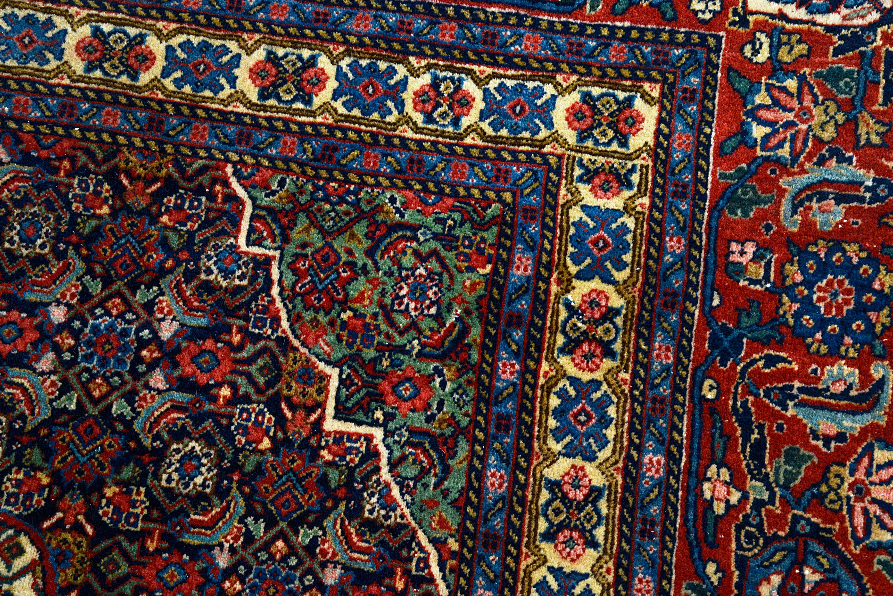 Close-up details of vintage Persian Tabriz carpet showing fine wool texture, motifs, and natural patina
