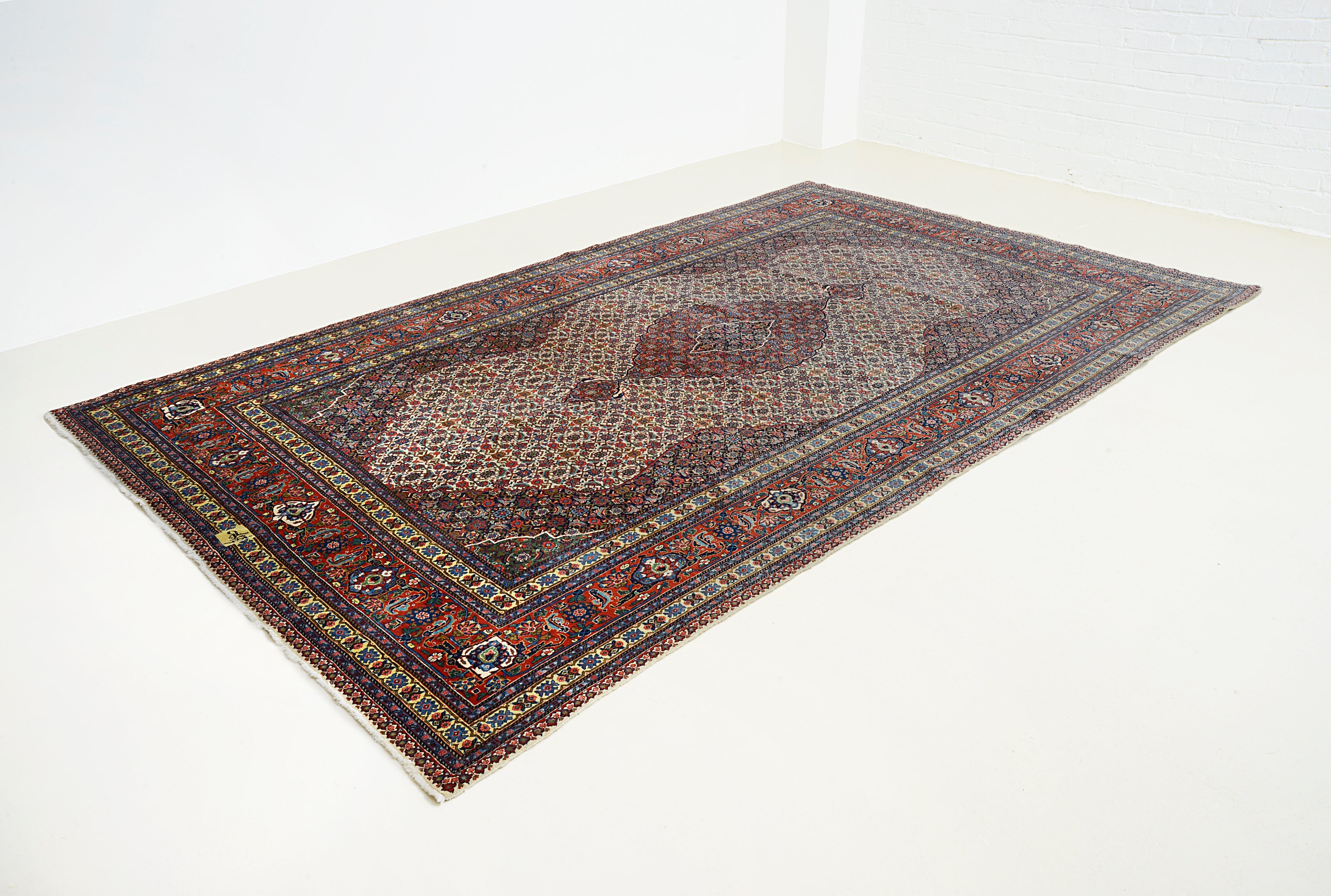 Large vintage Persian Tabriz carpet featuring detailed design and classic colour palette
