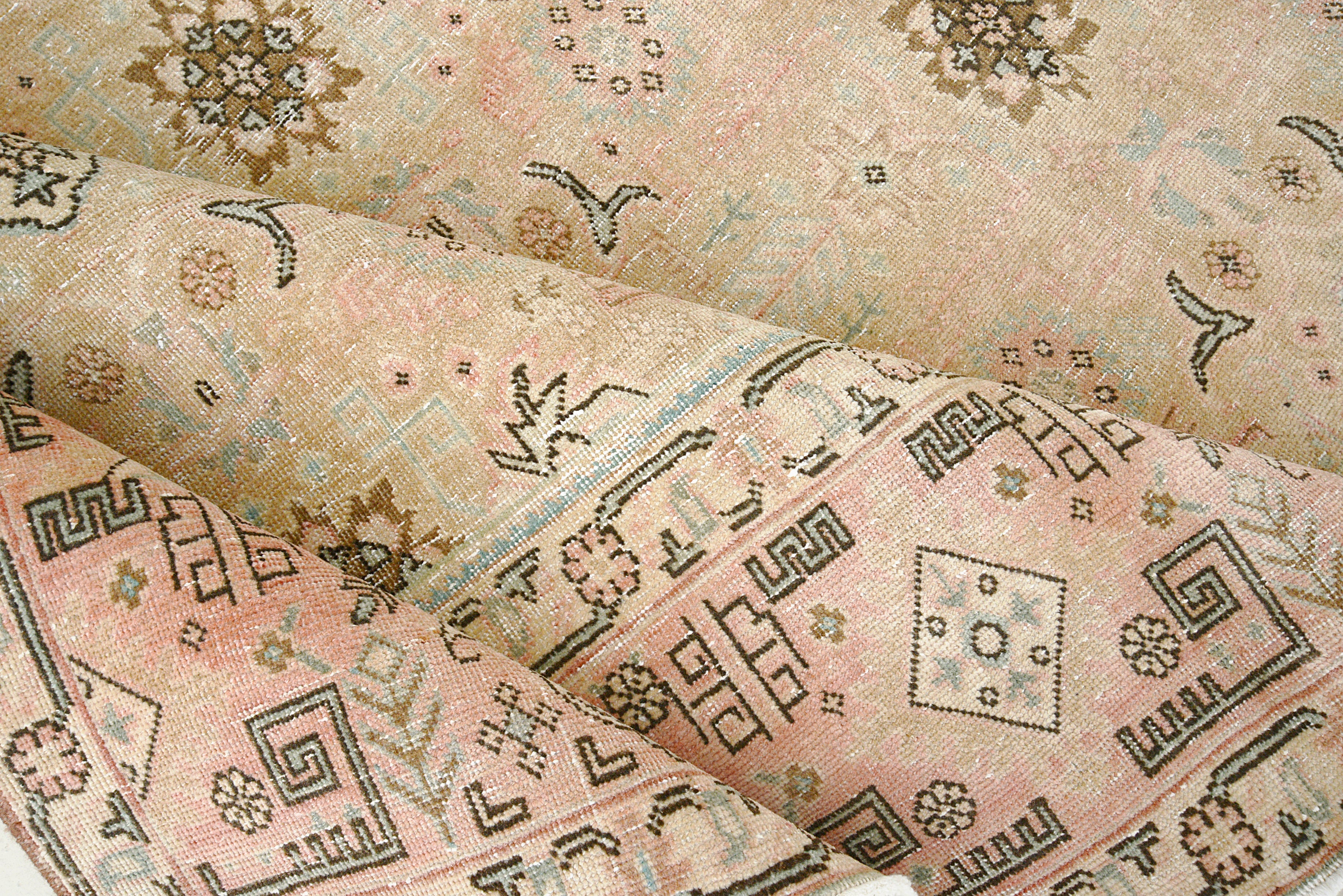 Close-up details of vintage Persian Tabriz carpet showing wool texture, borders, and natural patina
