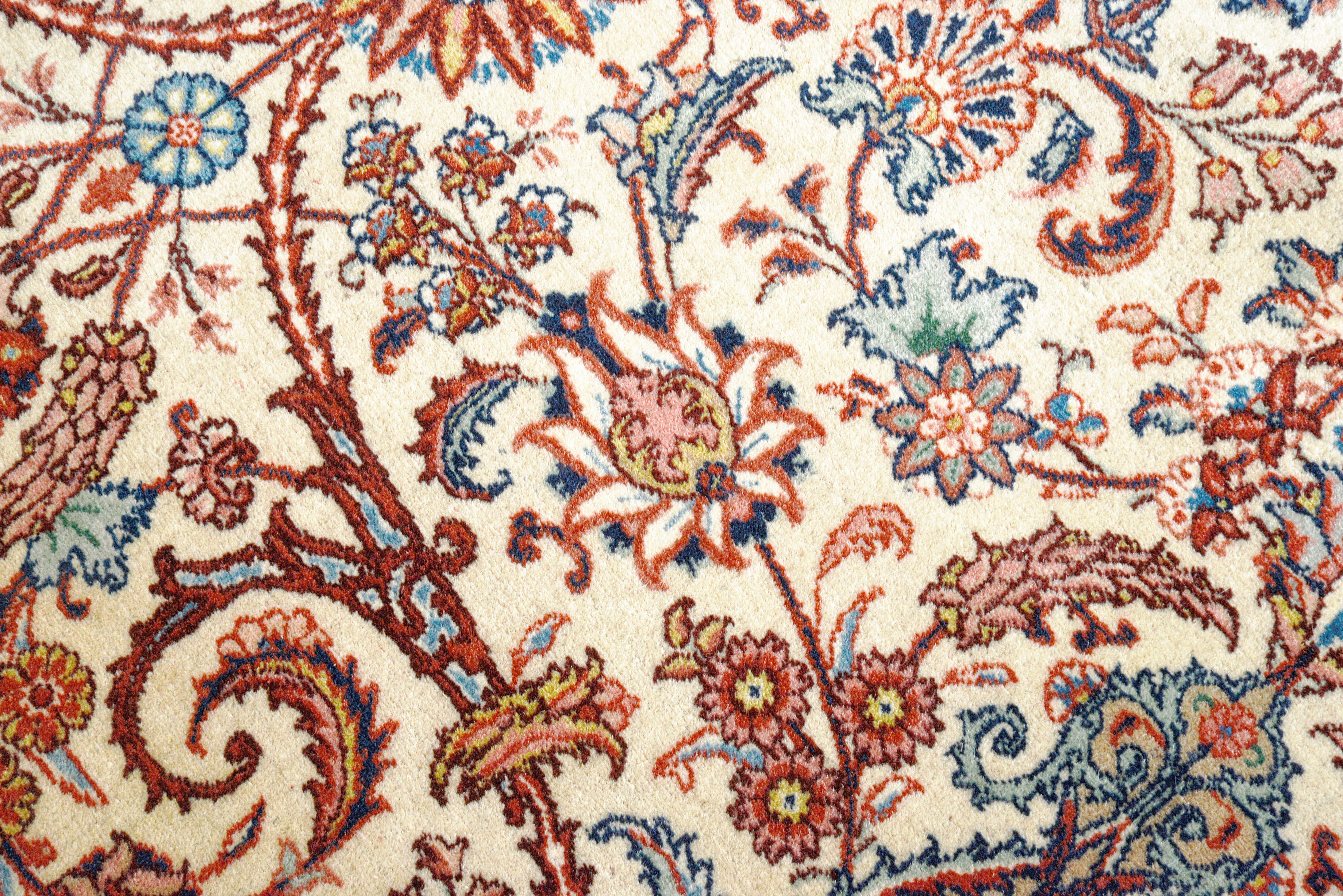 Close-up details of fine antique Persian Tabriz rug showing wool texture, floral motifs, and aged patina