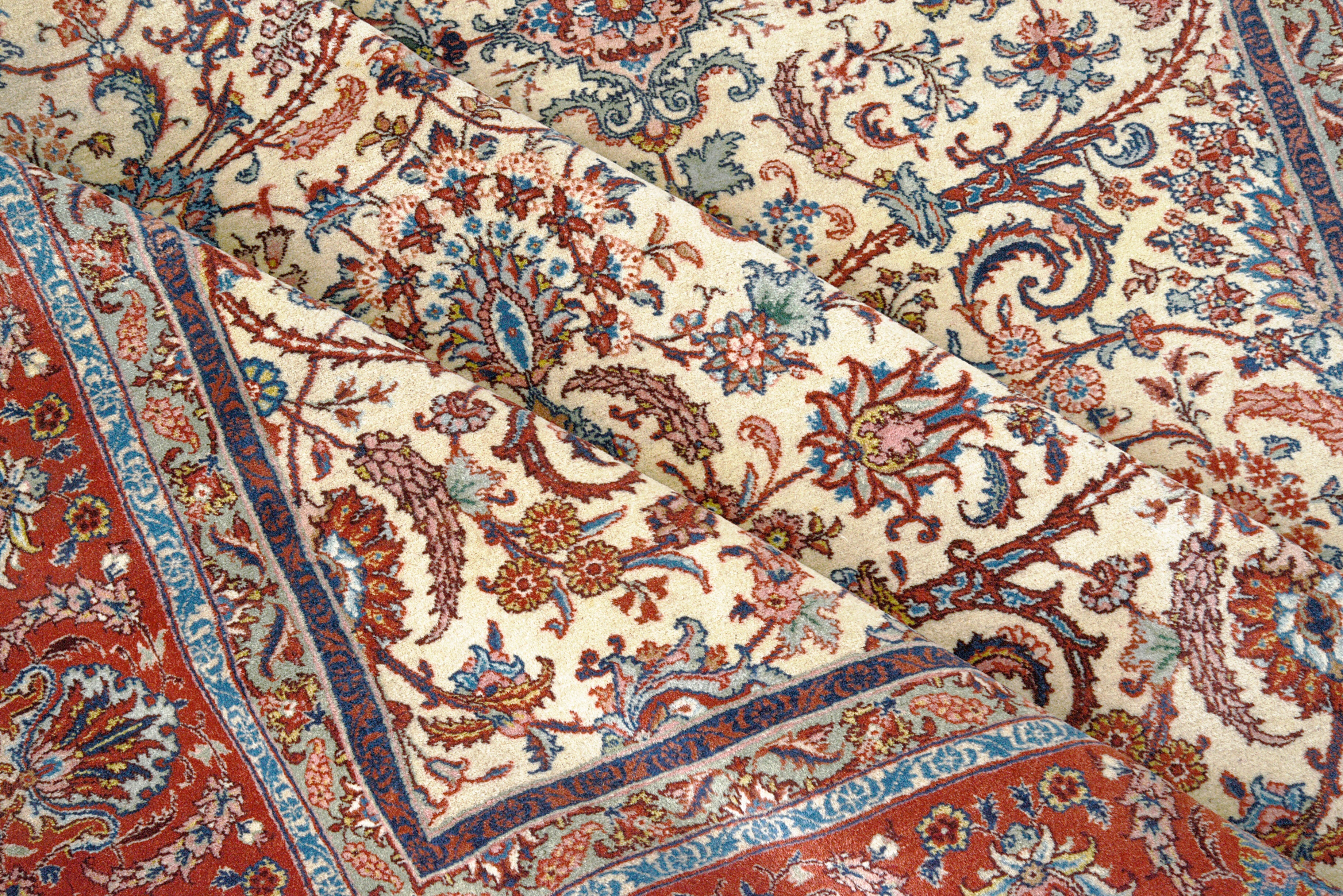 Close-up details of fine antique Persian Tabriz rug showing wool texture, floral motifs, and aged patina