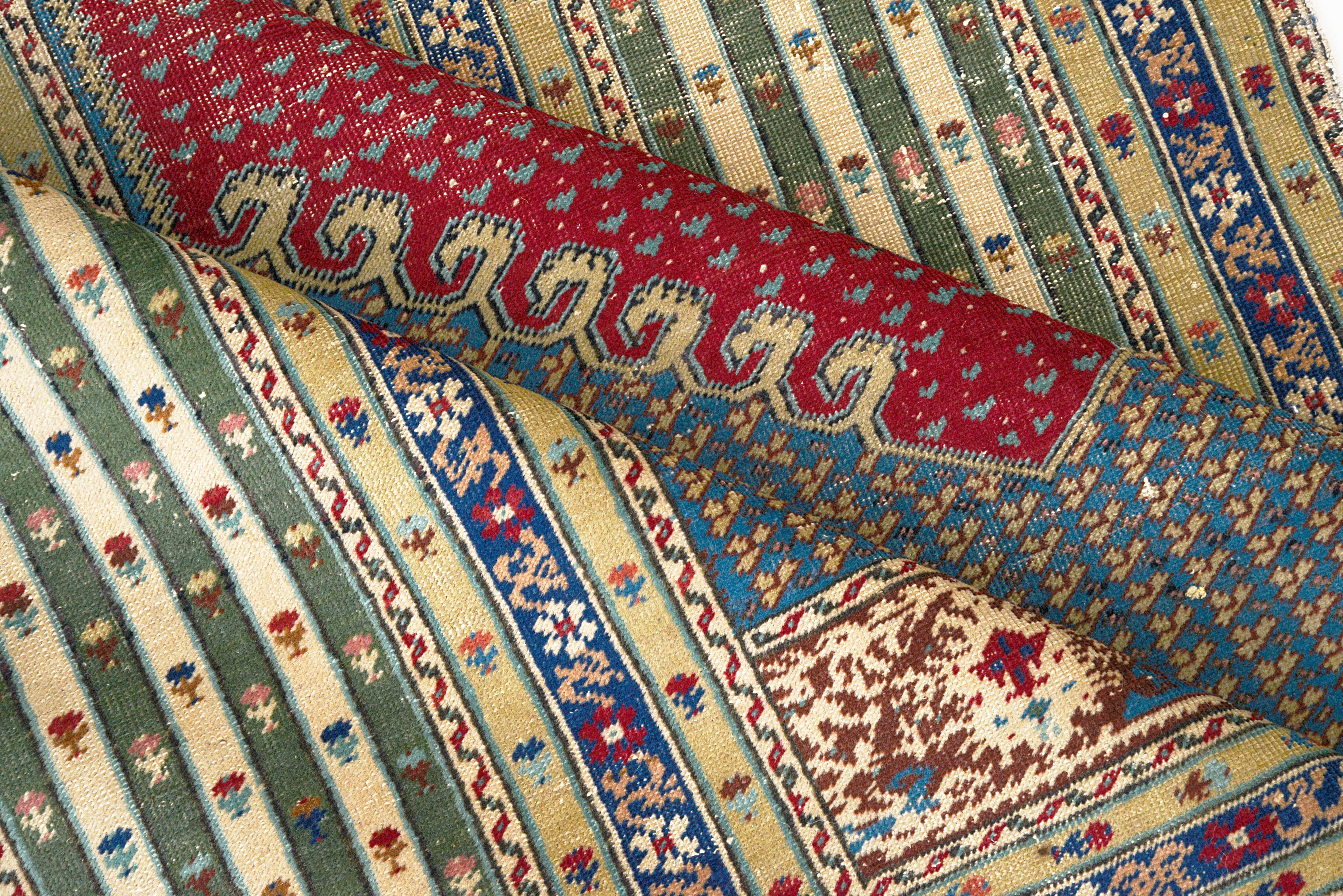 Close-up details of antique Turkish rug showing wool texture, motifs, and natural patina
