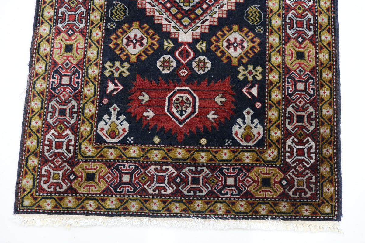 Close-up of antique Irawan runner with colourful geometric motifs and detailed border
