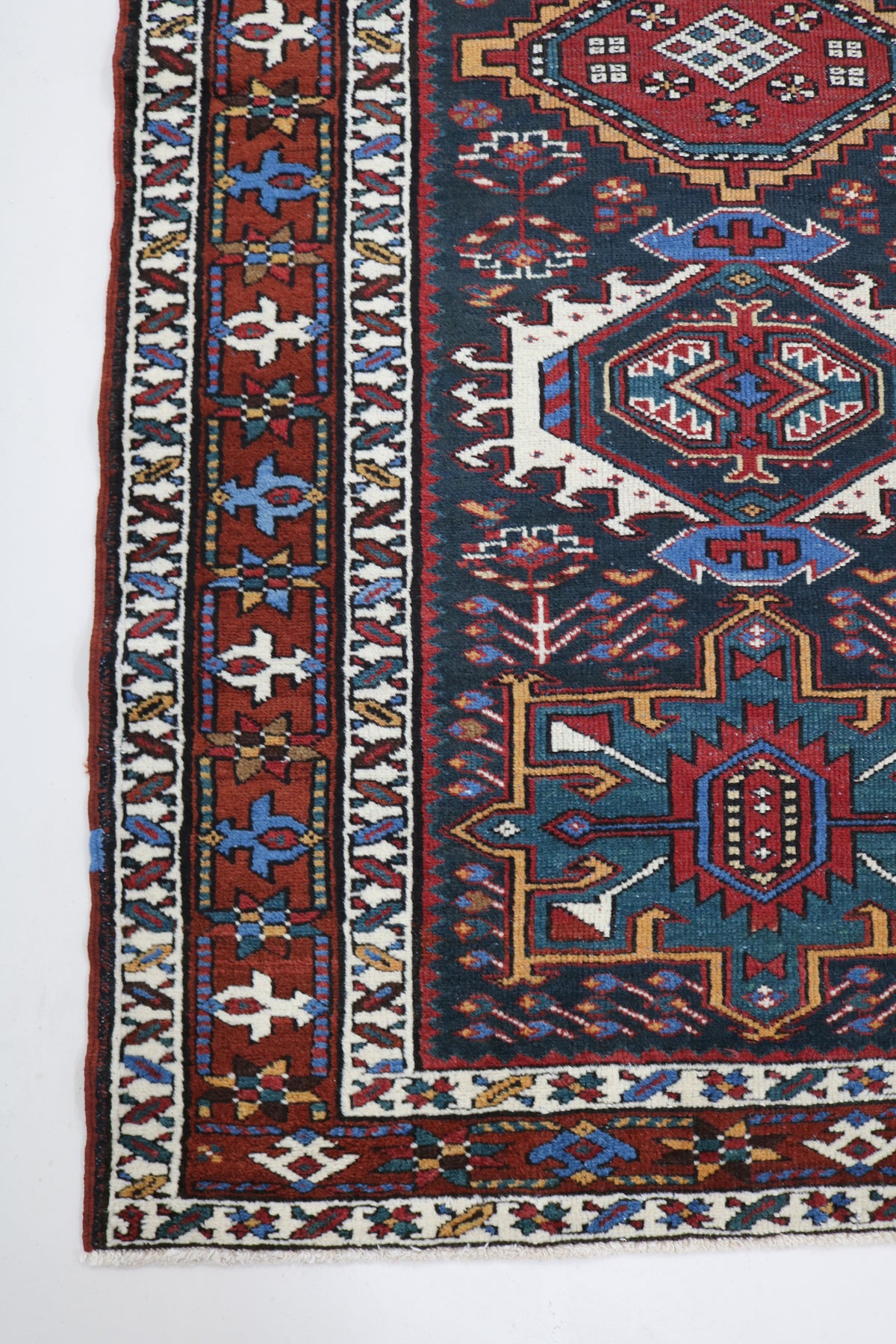 Antique Persian Heriz runner with deep indigo field, geometric medallions and red border
