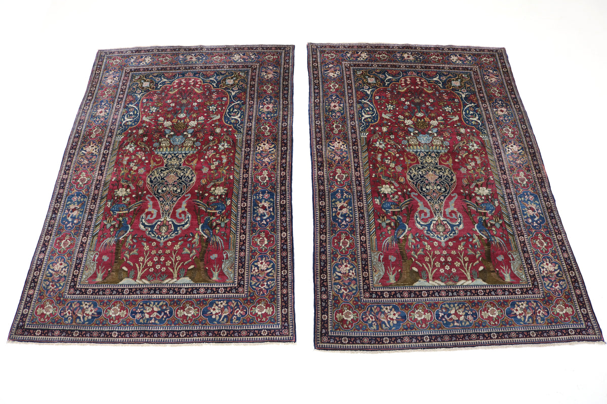 Two antique Isfahan rugs displayed together with richly detailed floral patterns and borders