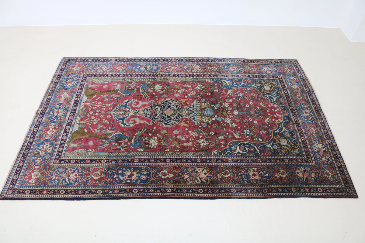 Angled view of Persian Isfahan rug showing rich red tones and intricate floral pattern