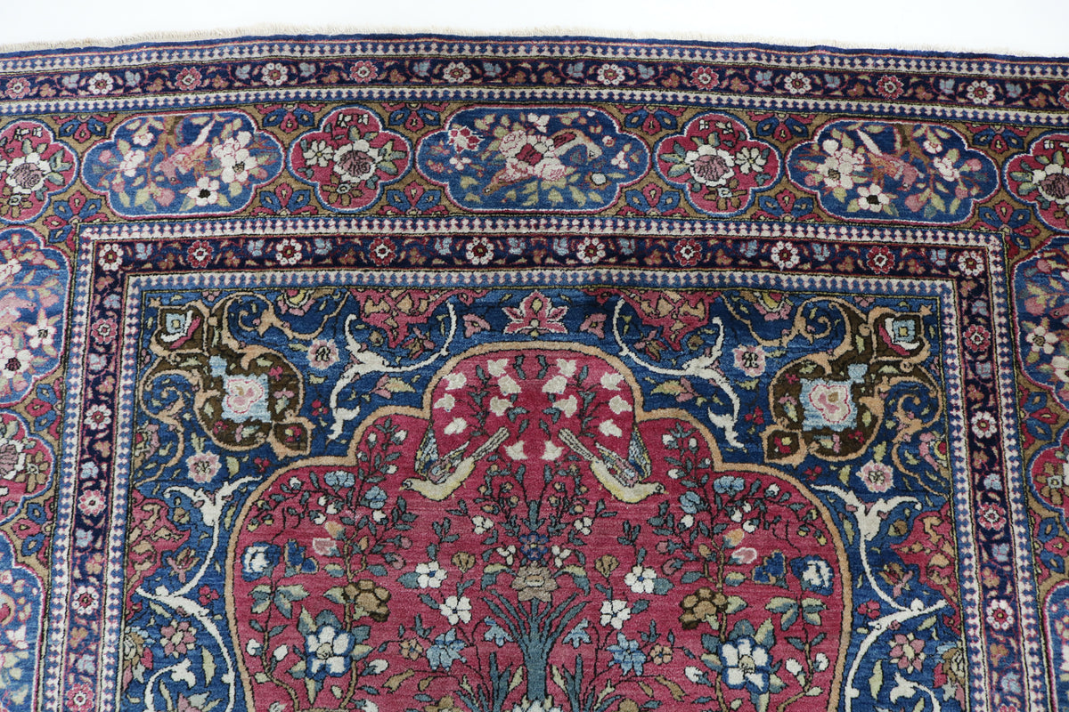 Close-up of antique Isfahan rug border with floral motifs in blue, red and ivory