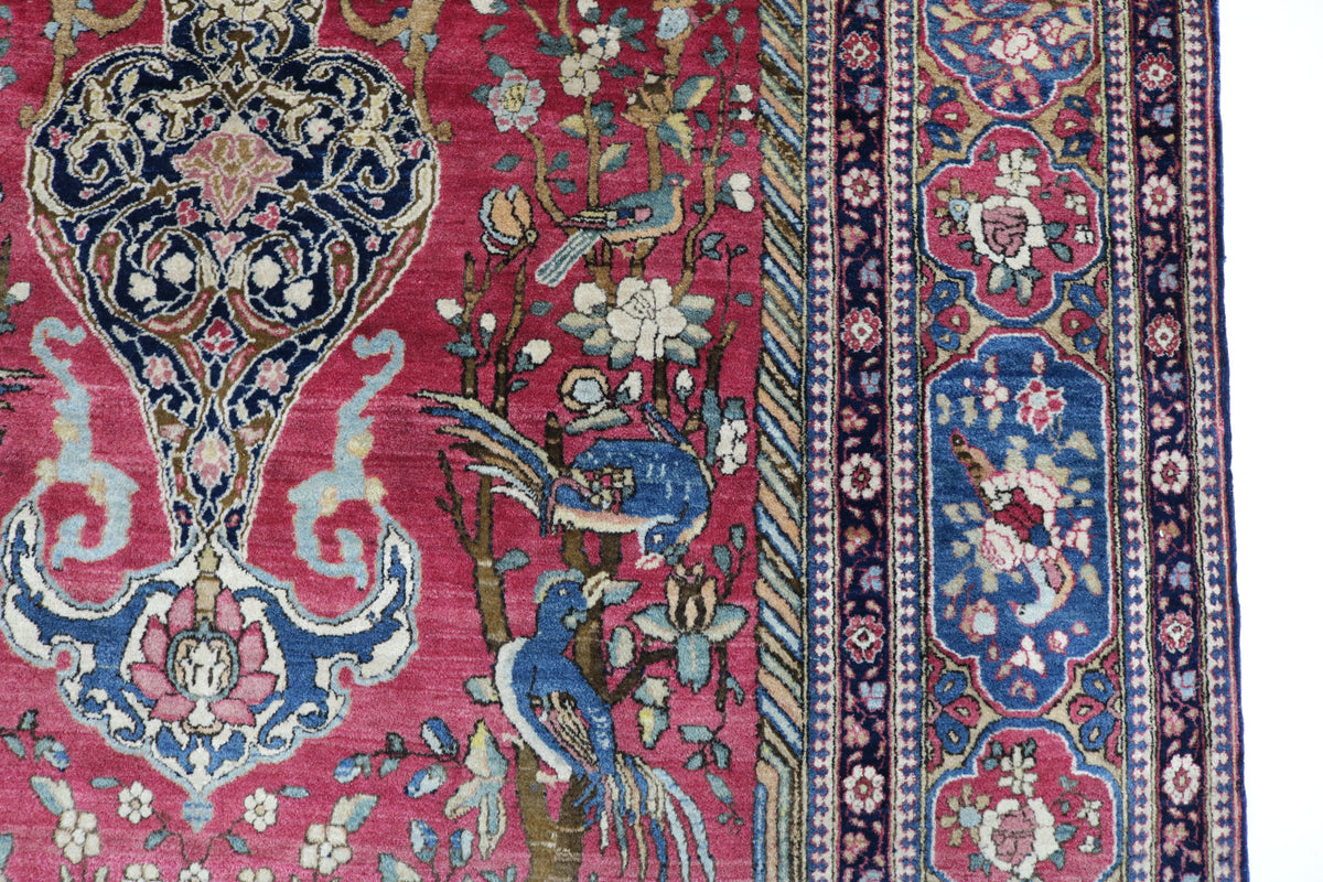 Close-up of Persian Isfahan rug showing intricate floral design and richly coloured border