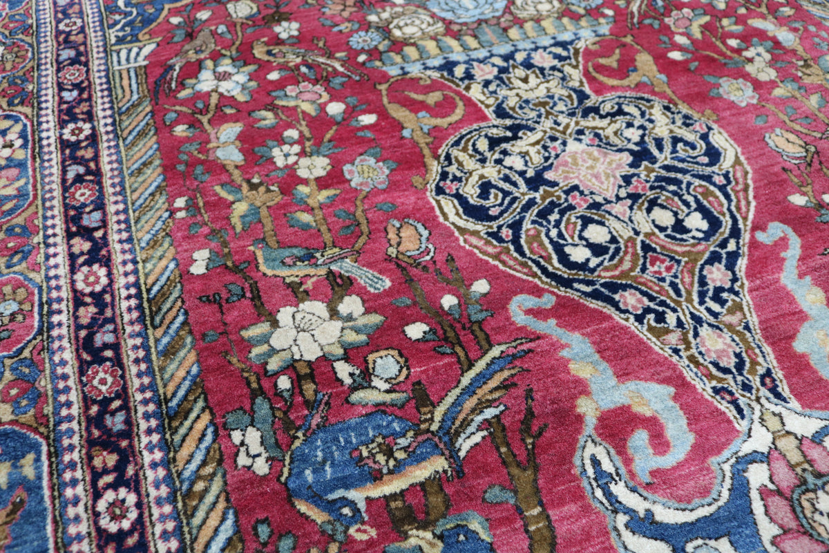 Detailed antique Isfahan rug with flowing floral motifs across a deep red field