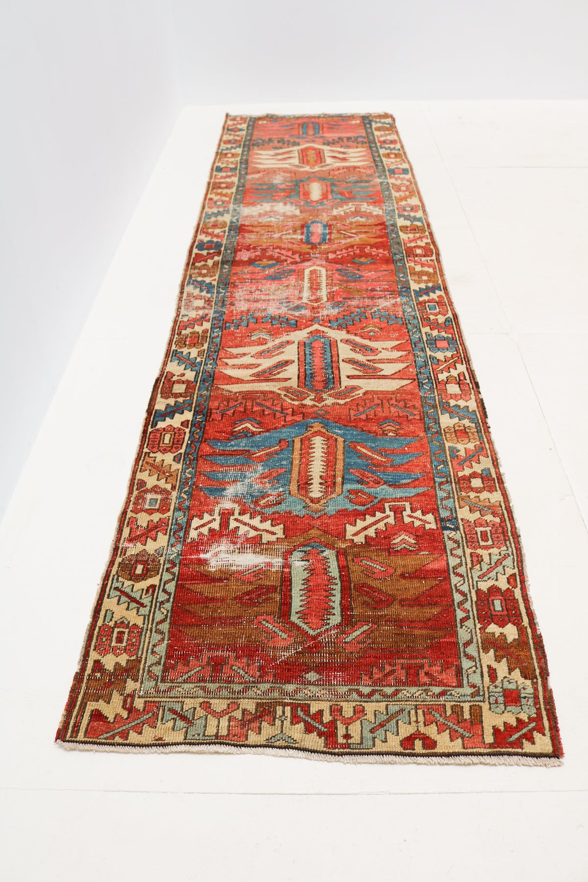 Antique Persian runner rug shown in full with traditional geometric pattern and decorative borders