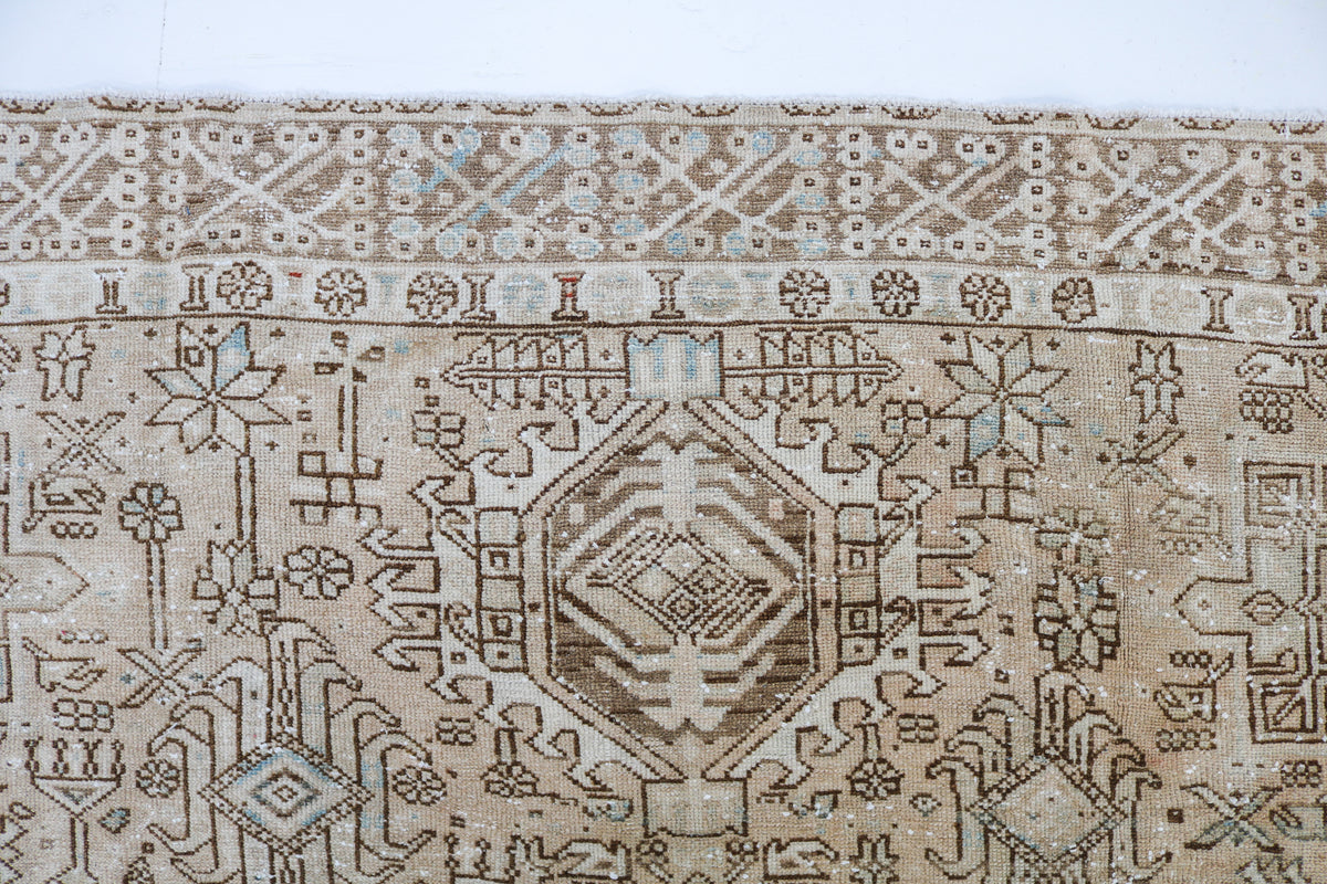 Detailed carpet border featuring traditional geometric patterns in beige, ivory and muted taupe