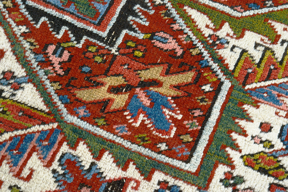 Detailed Heriz carpet field with bold angular motifs in terracotta, blue and ivory