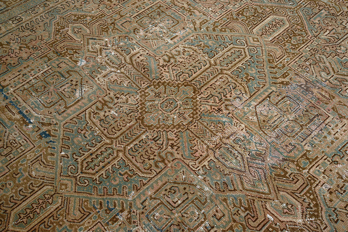 Close-up of Heriz carpet showing intricate geometric motifs in soft earth tones
