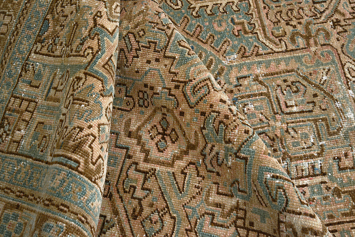 Close-up of Heriz carpet showing softly muted geometric motifs and blue accents
