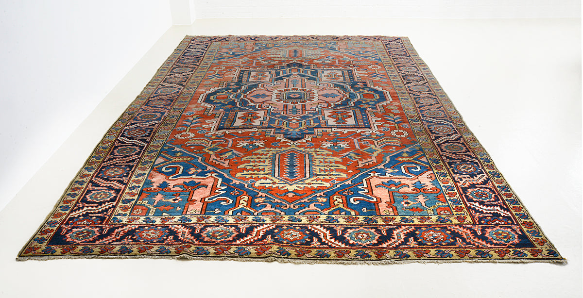 Full view of antique Heriz carpet with bold architectural design and richly patterned field