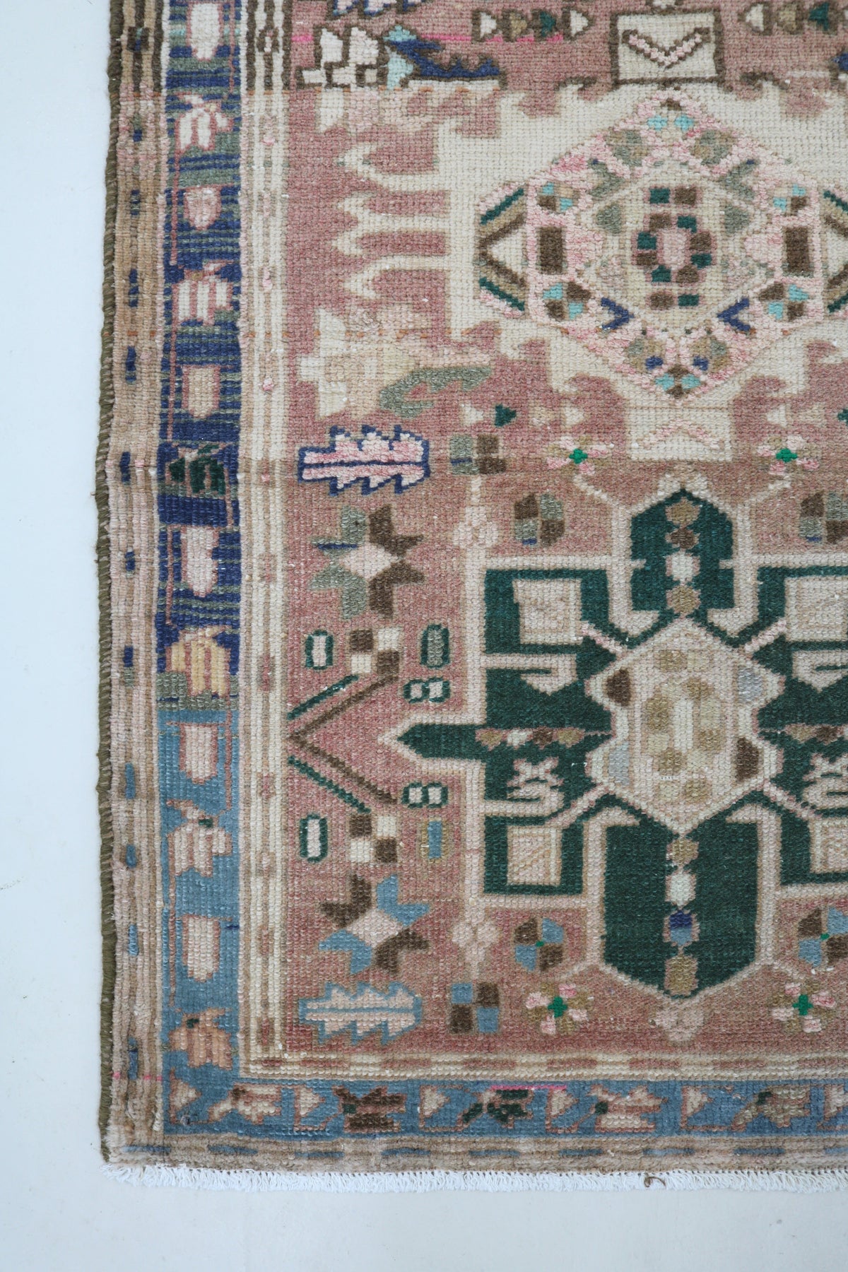 Antique Persian Heriz runner with muted pink field, blue border and geometric motifs