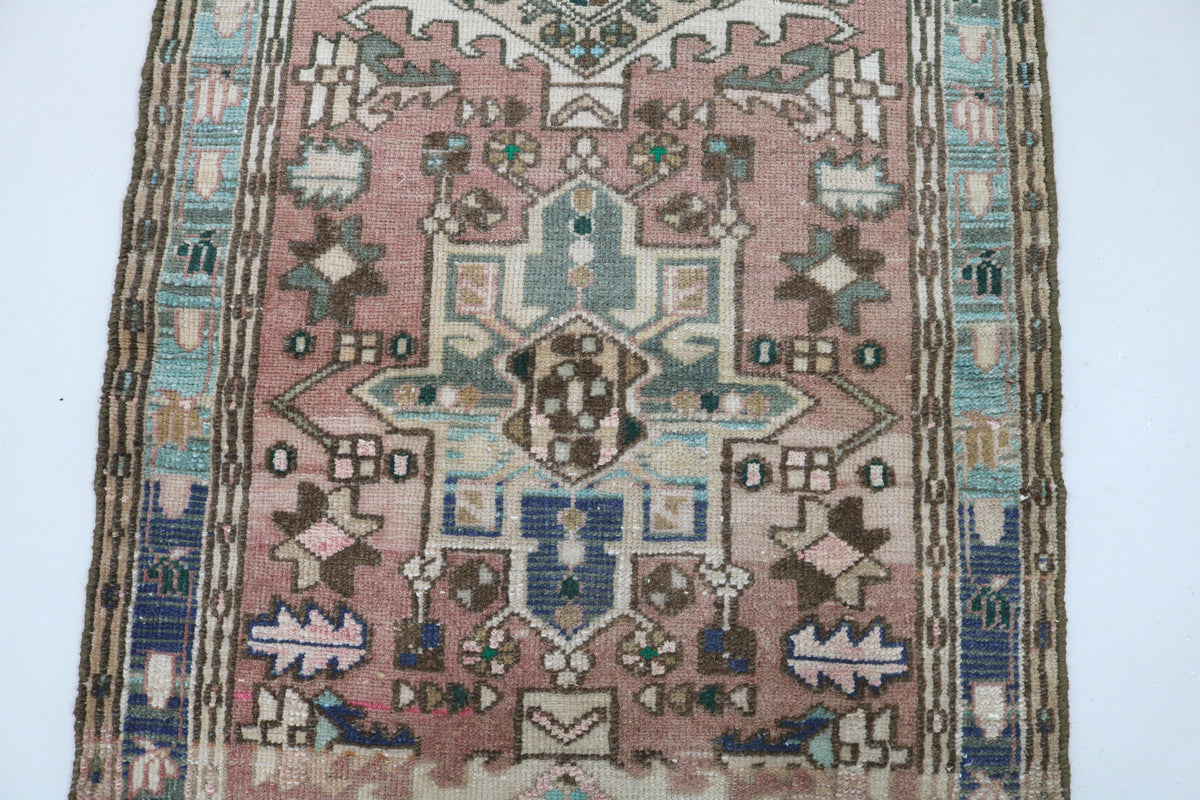 Close-up of Heriz rug featuring bold geometric motifs with blue and green accents
