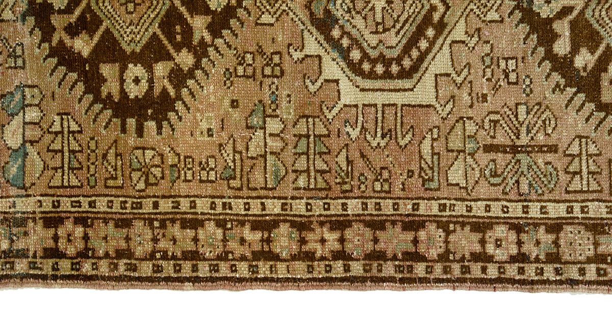 Close-up of Heriz runner border featuring geometric motifs in brown, beige and muted blue
