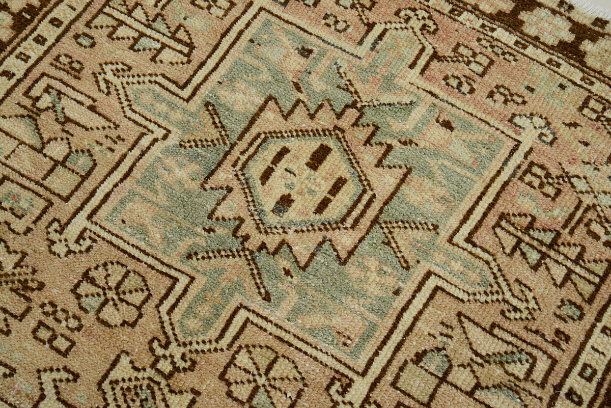 Close-up of antique Persian Heriz runner showing central geometric medallion in muted blue