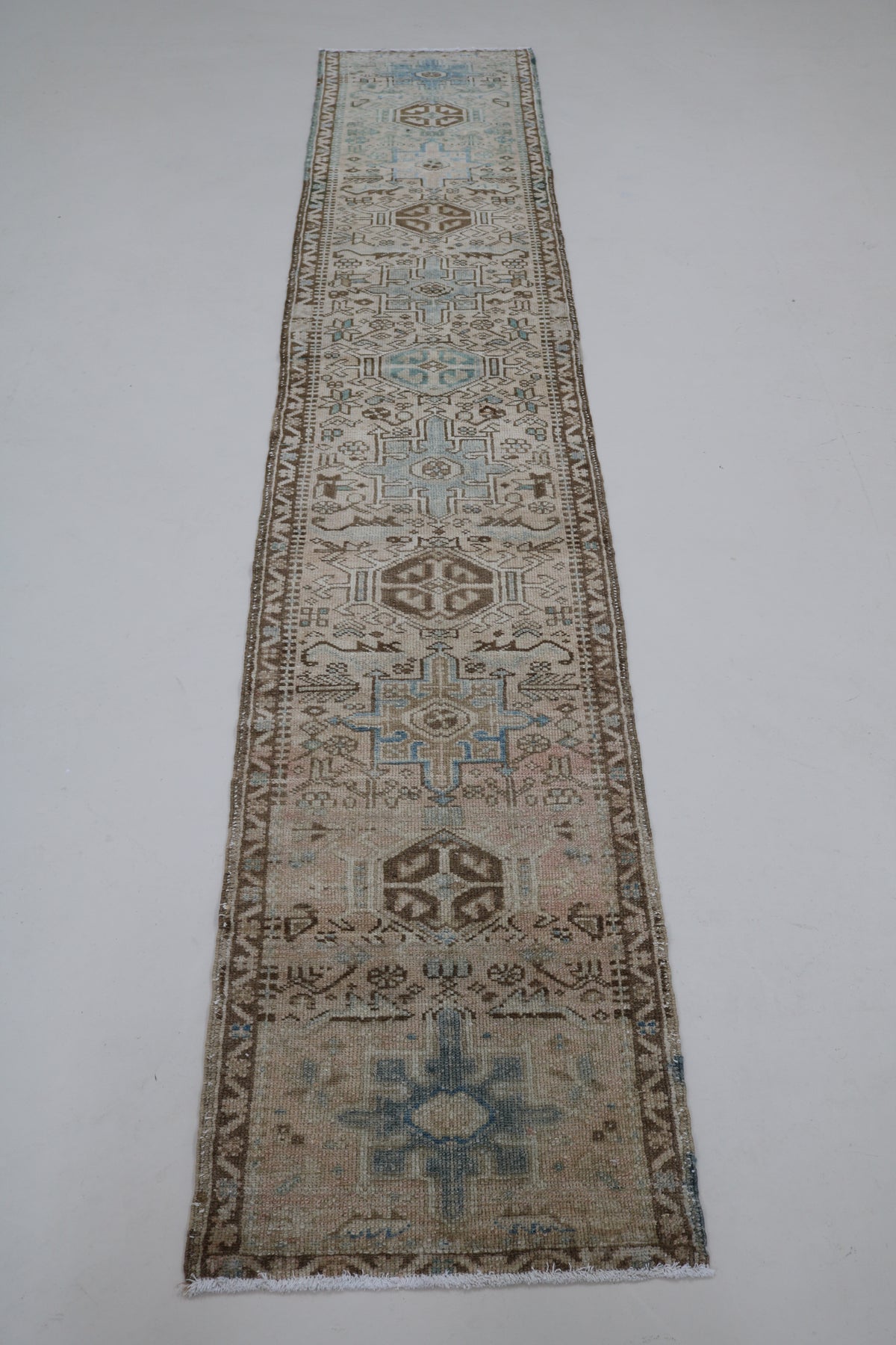 Full Heriz runner showing long narrow design with repeating geometric medallions
