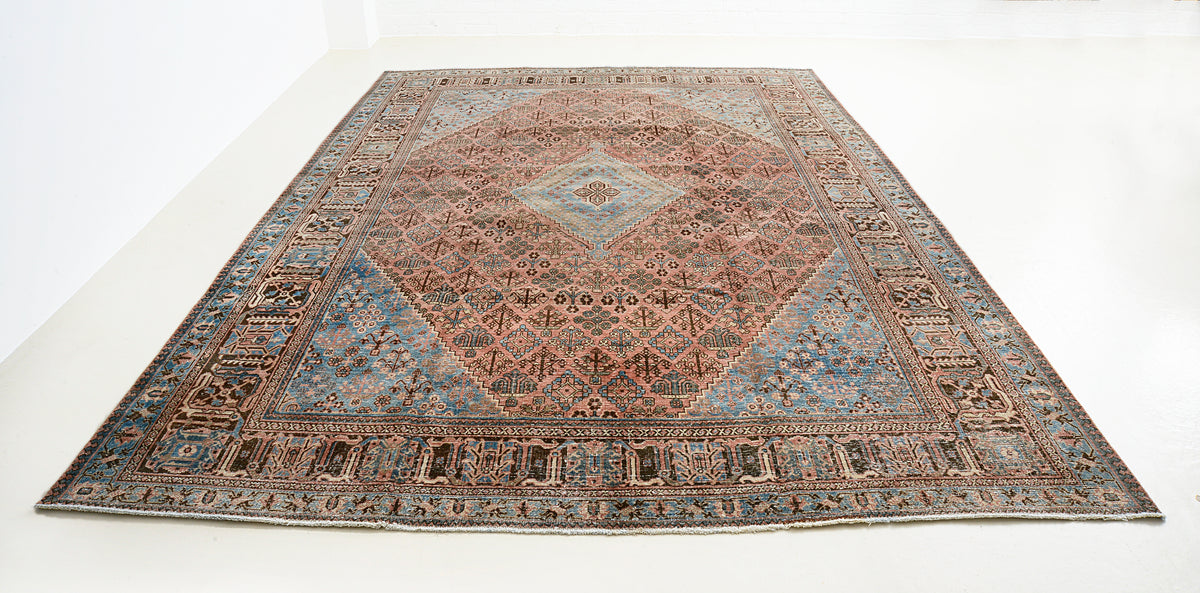 Full view of antique Josheqan rug with central diamond medallion and geometric lattice design
