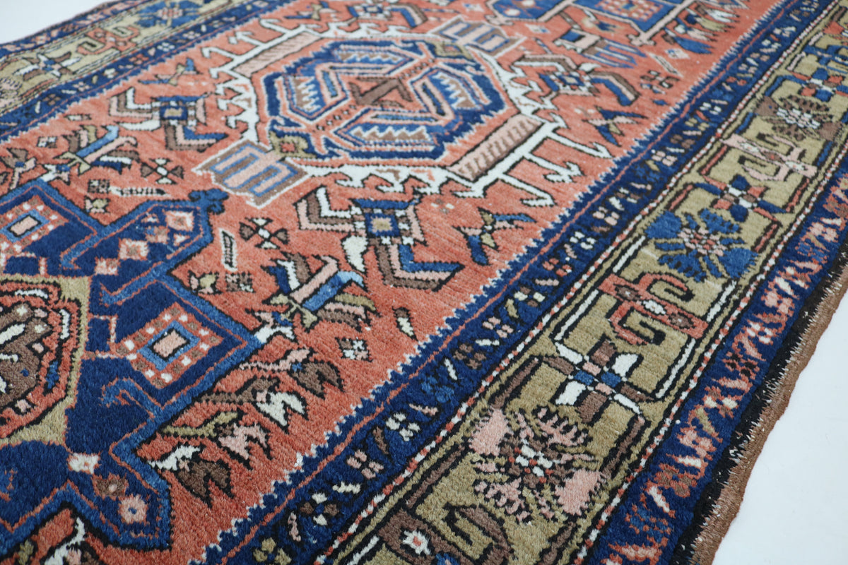 Angled view highlighting rust red geometric patterns and deep blue border details