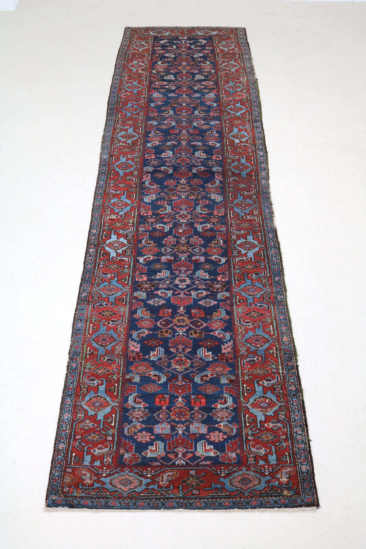 Full view of antique Malayer runner with open Herati design and richly patterned border
