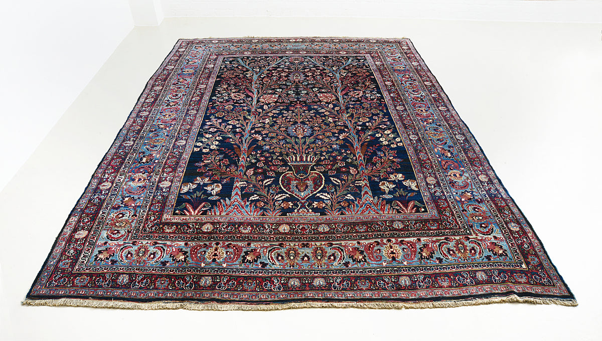 Full view of antique Mashhad carpet with intricate floral design in indigo, red and ivory