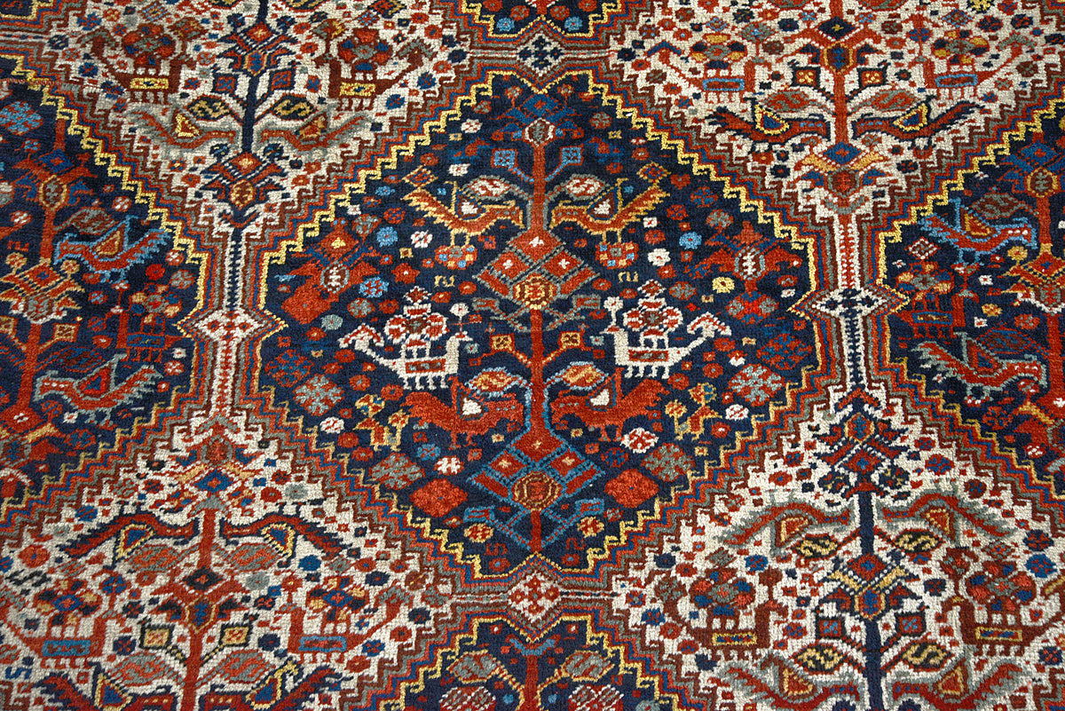 Detailed view of Qashqai carpet field featuring diamond motifs in deep red, indigo and ivory