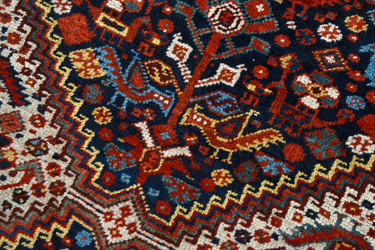 Close-up of Persian Qashqai carpet with geometric tribal motifs in indigo, red and ivory