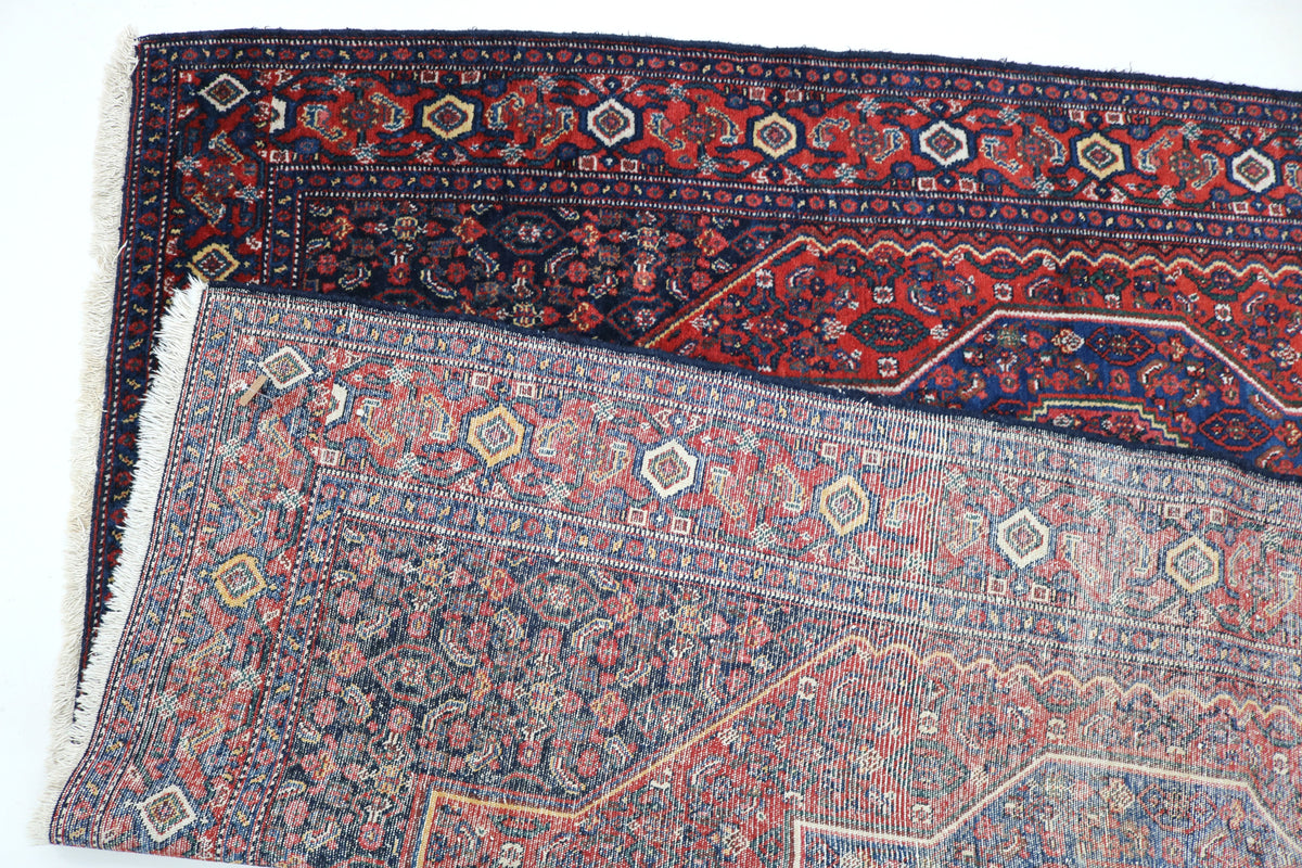 Folded Senneh rug showing patterned reverse with fine all-over decorative design