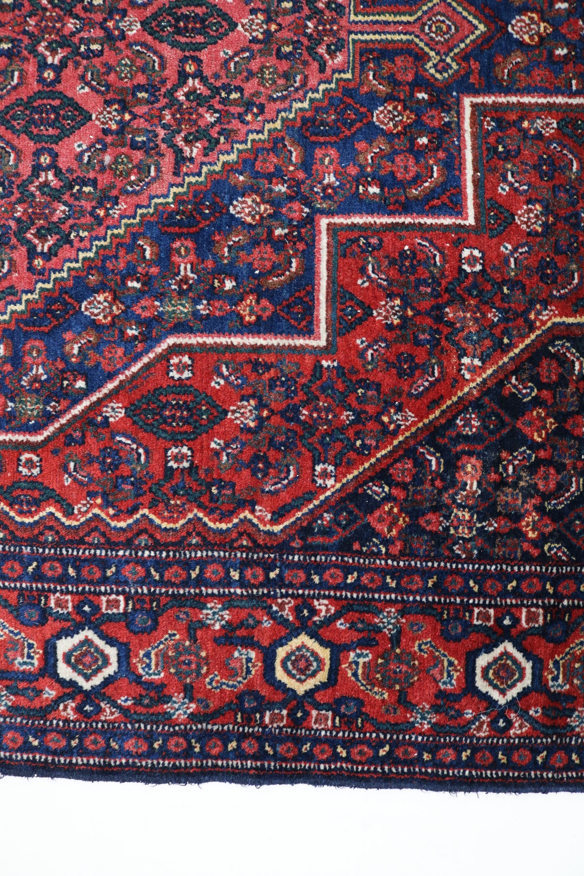 Close-up of Senneh rug with bold stepped motifs and intricate floral details