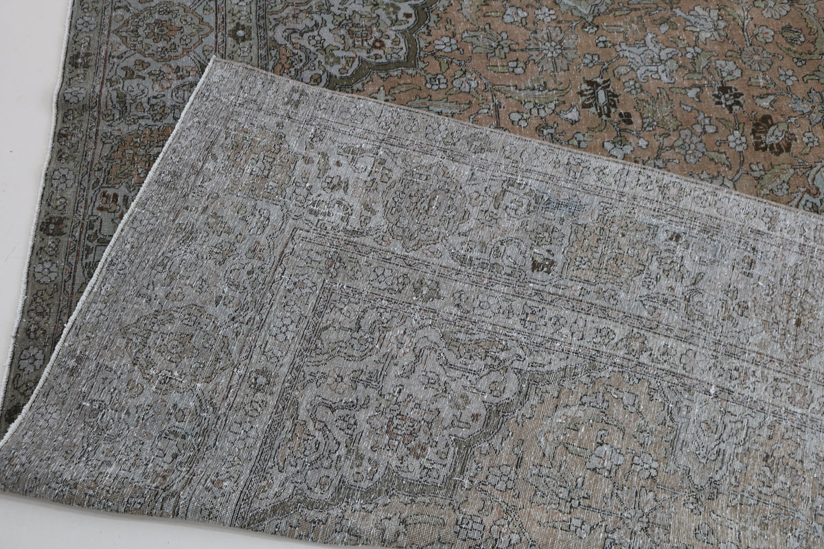 Folded Tabriz carpet showing detailed pattern and woven reverse side