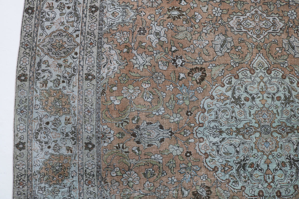 Close-up of antique Tabriz carpet showing fine floral detailing and border
