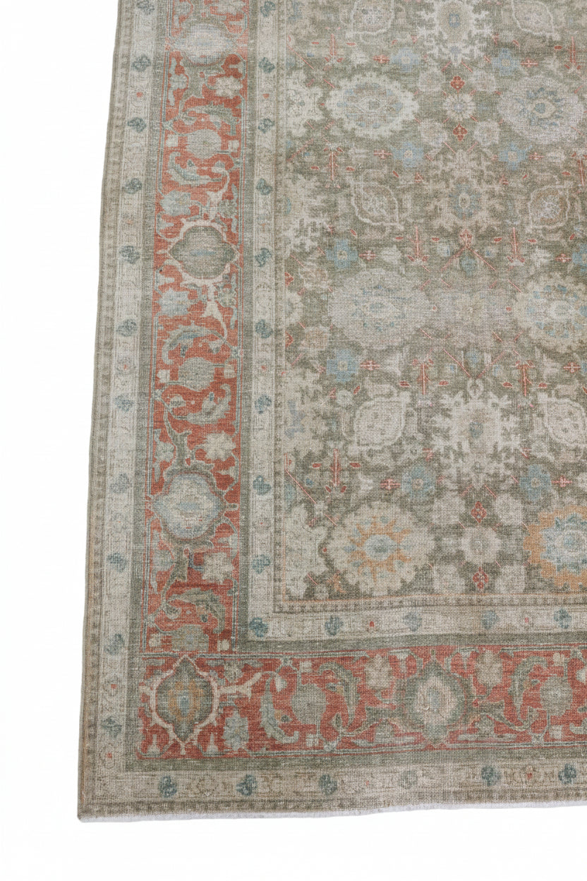 Antique Persian Tabriz rug with faded floral motifs, muted green and terracotta tones