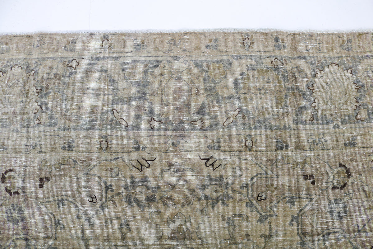 Close-up of Persian Tabriz carpet showing fine floral design and woven texture