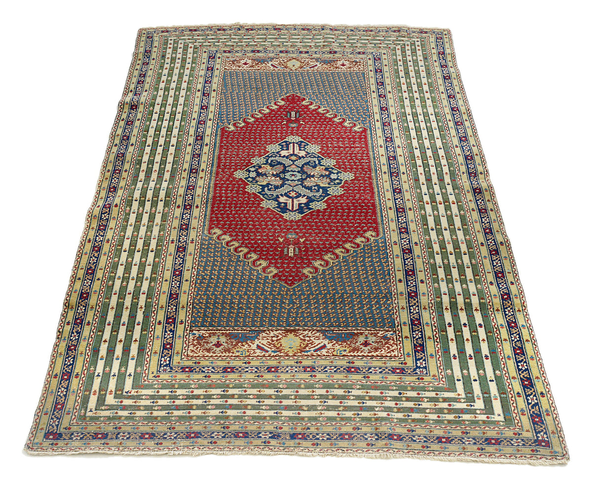 Full view of antique Turkish rug with central medallion and multicoloured patterned borders
