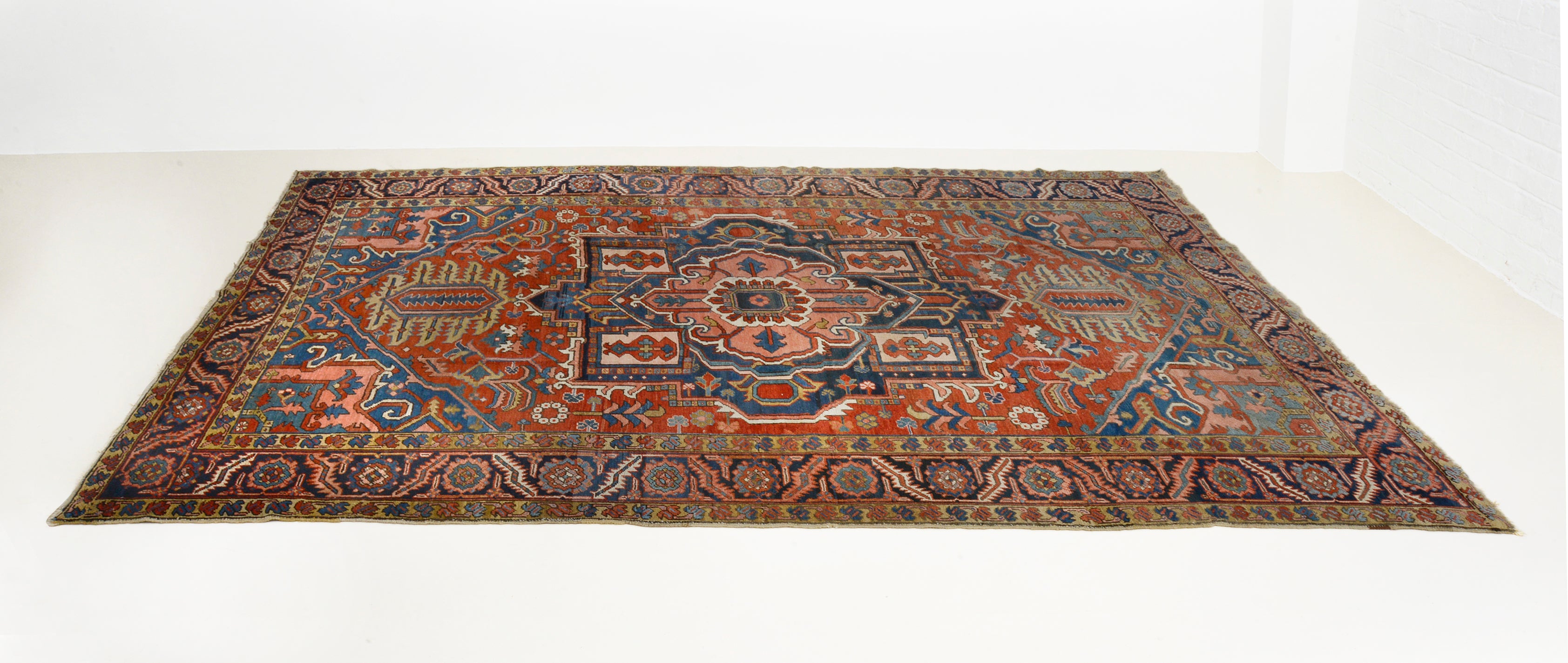 Perspective view of antique Persian Heriz carpet on floor
