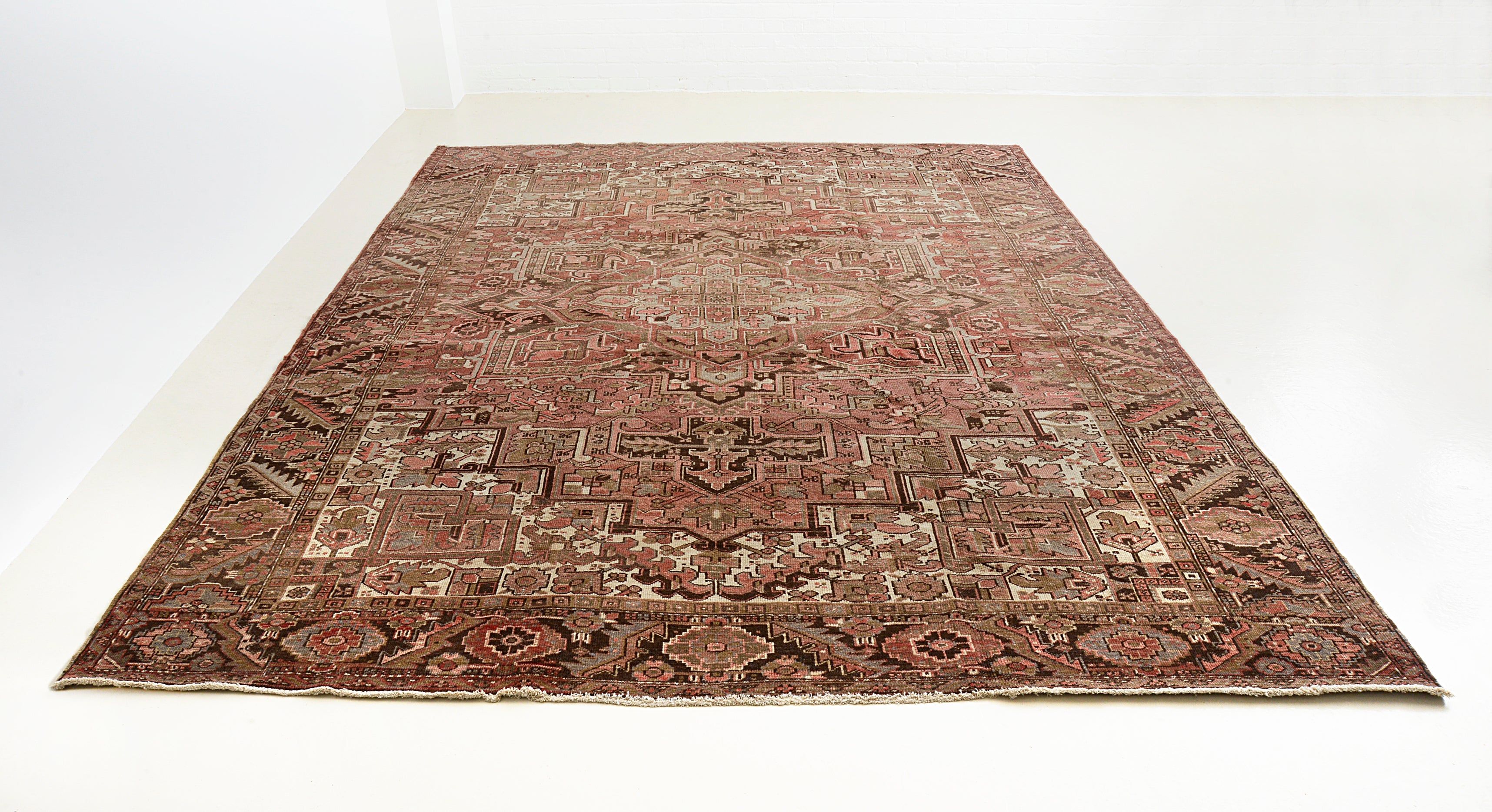 Full view of antique Persian Heriz carpet with traditional geometric layout

