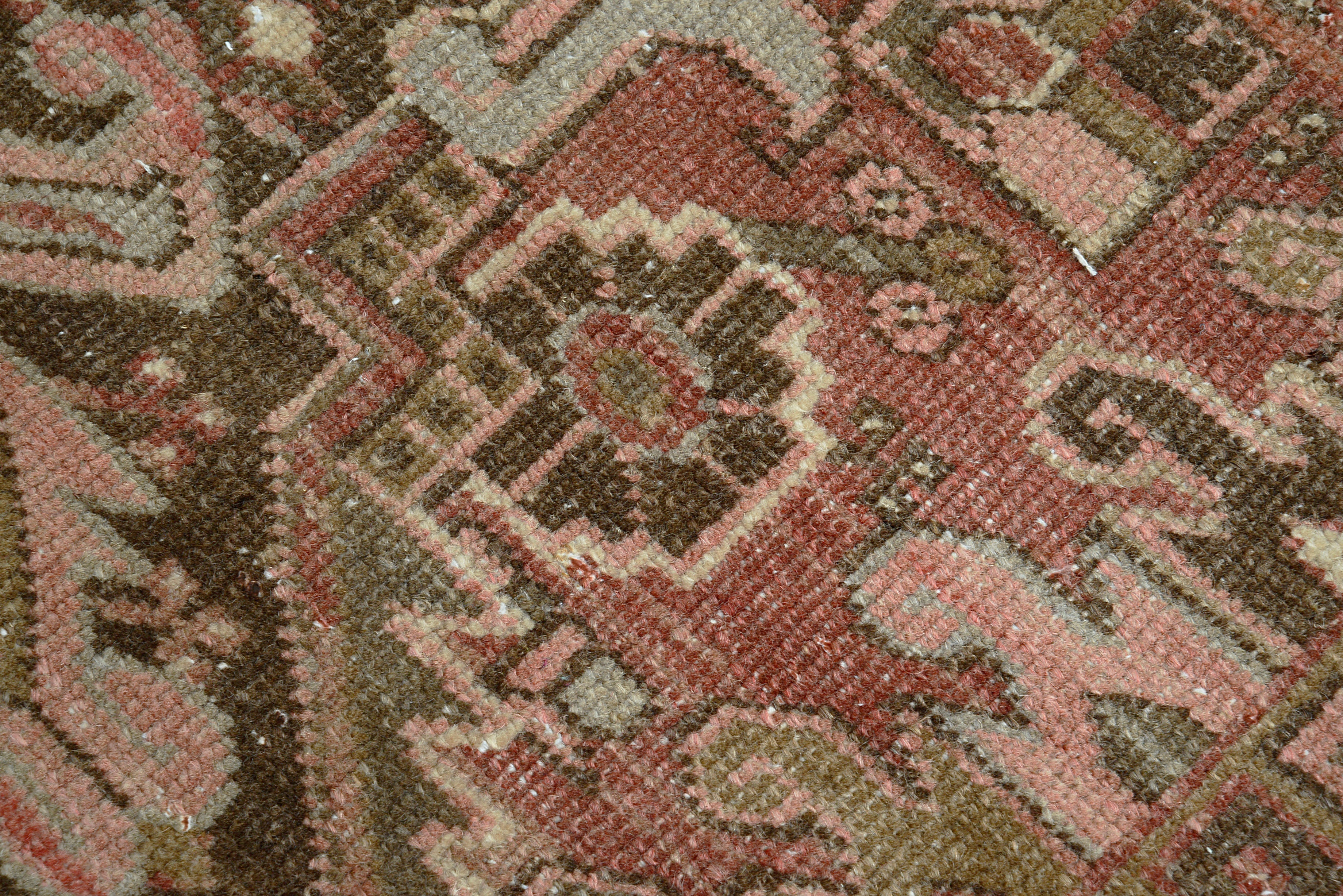 Close-up showing aged colours and patina on antique Persian Heriz carpet

