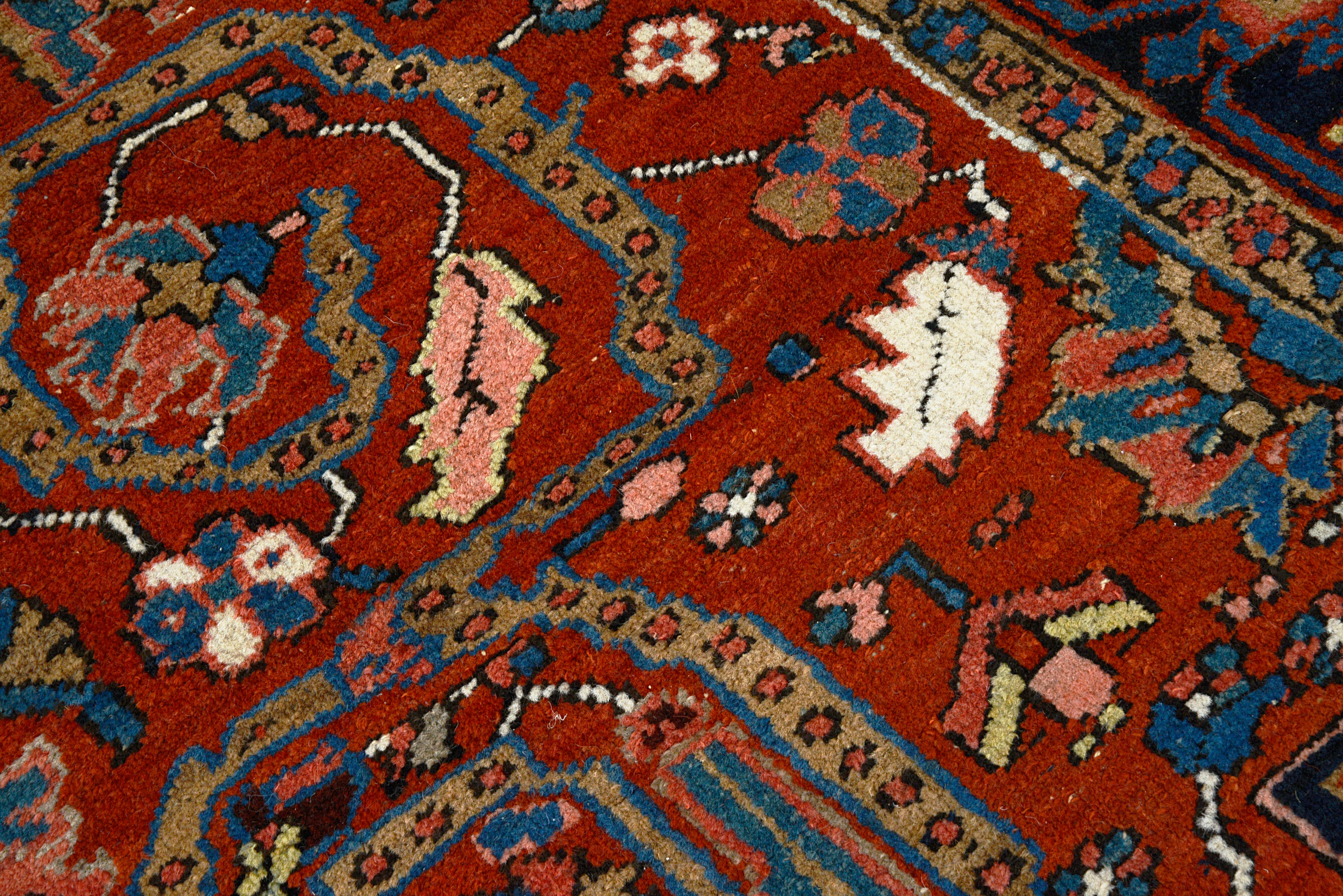 Close-up showing rich colors and drawing on antique Persian Heriz carpet
