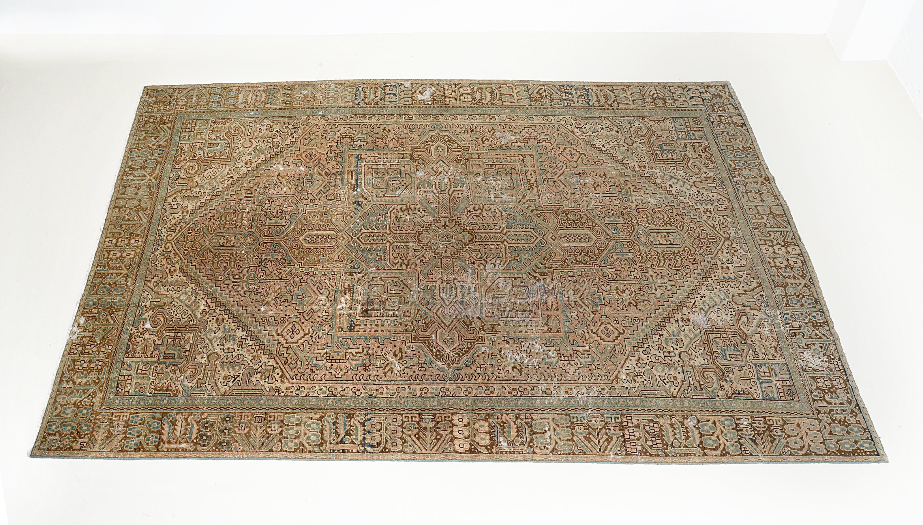Angled view of antique Persian Heriz carpet showing overall pattern
