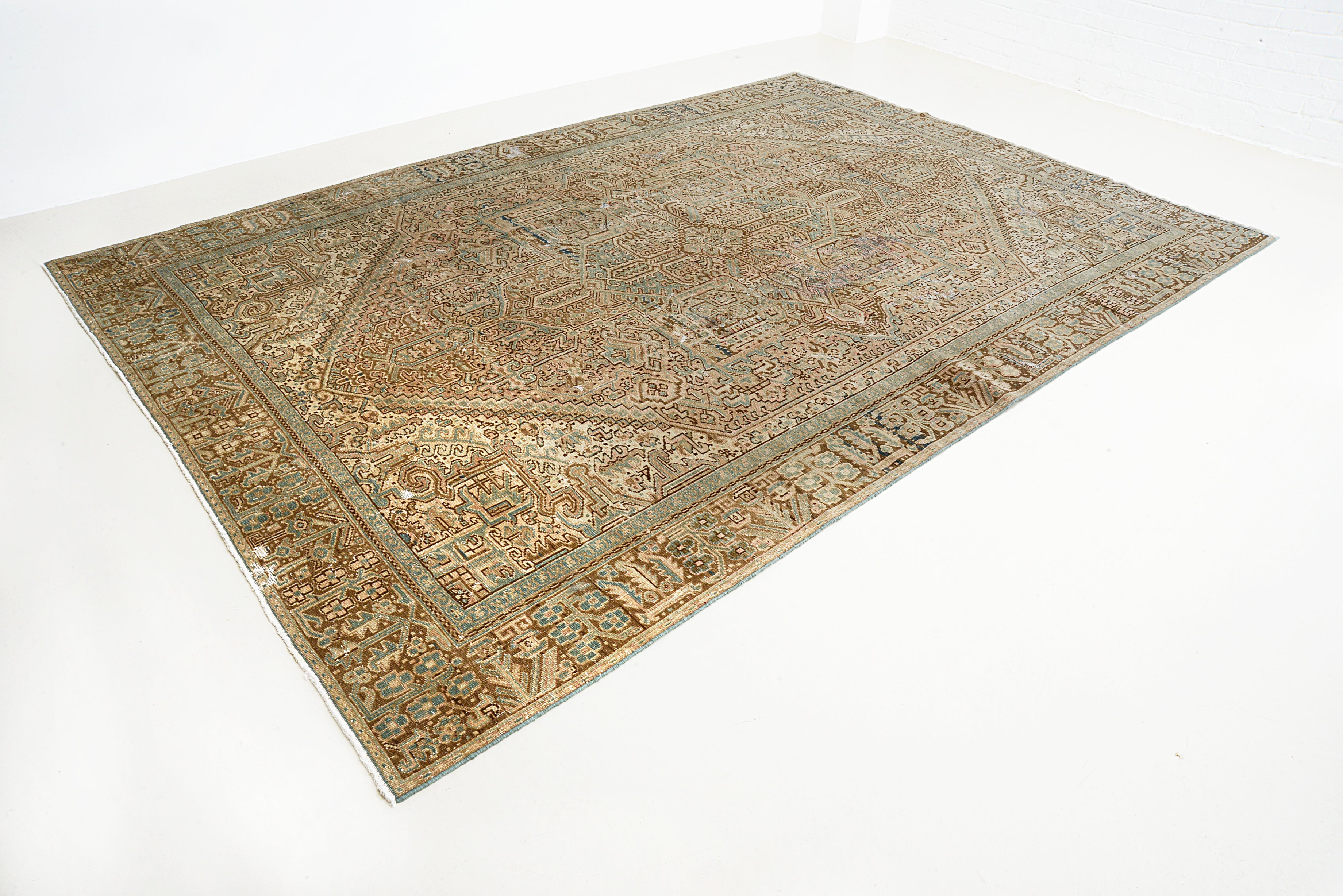 Perspective view of antique Persian Heriz carpet on floor
