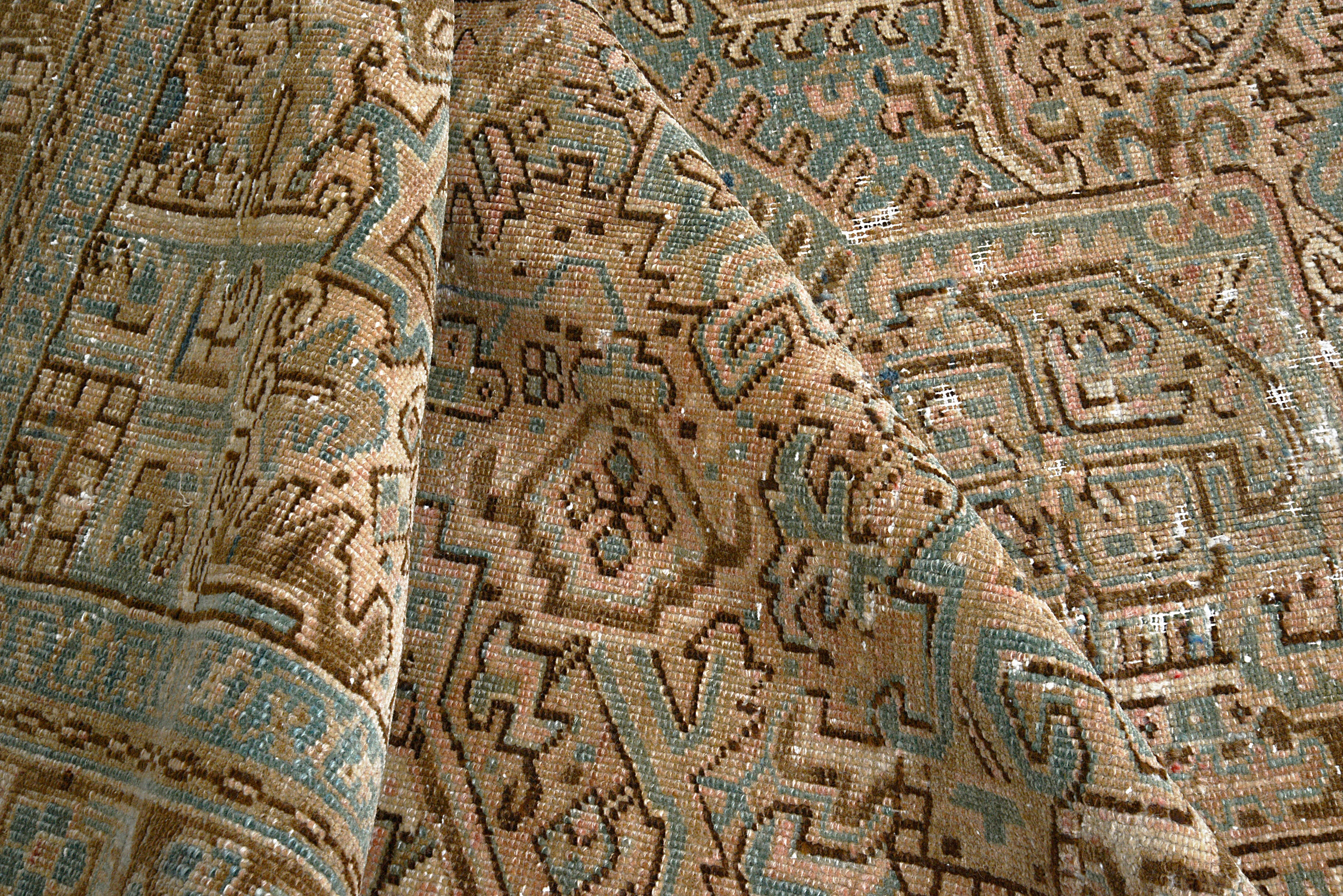 Close-up of hand-knotted wool texture on antique Persian Heriz carpet


