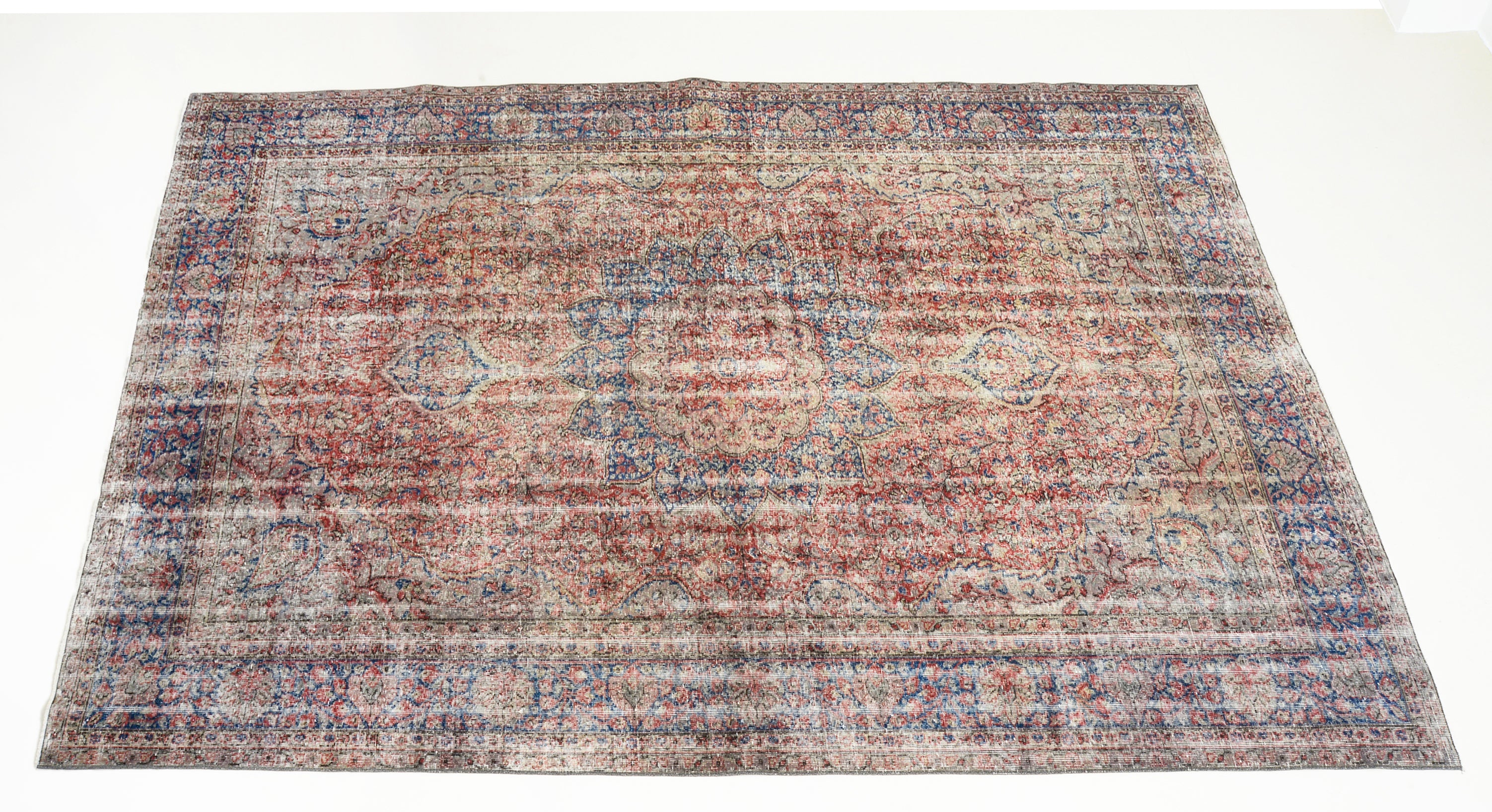 Angled view of vintage Turkish carpet showing field and border patterns
