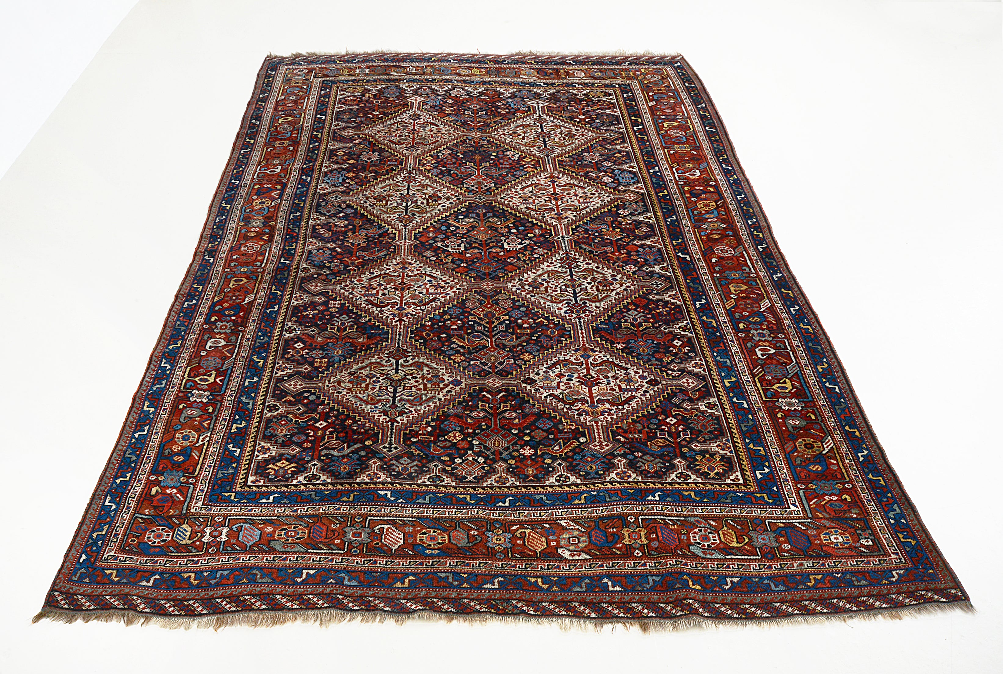 Full view of an antique Persian Qashqai carpet woven circa 1900, measuring 292 x 206 cm
