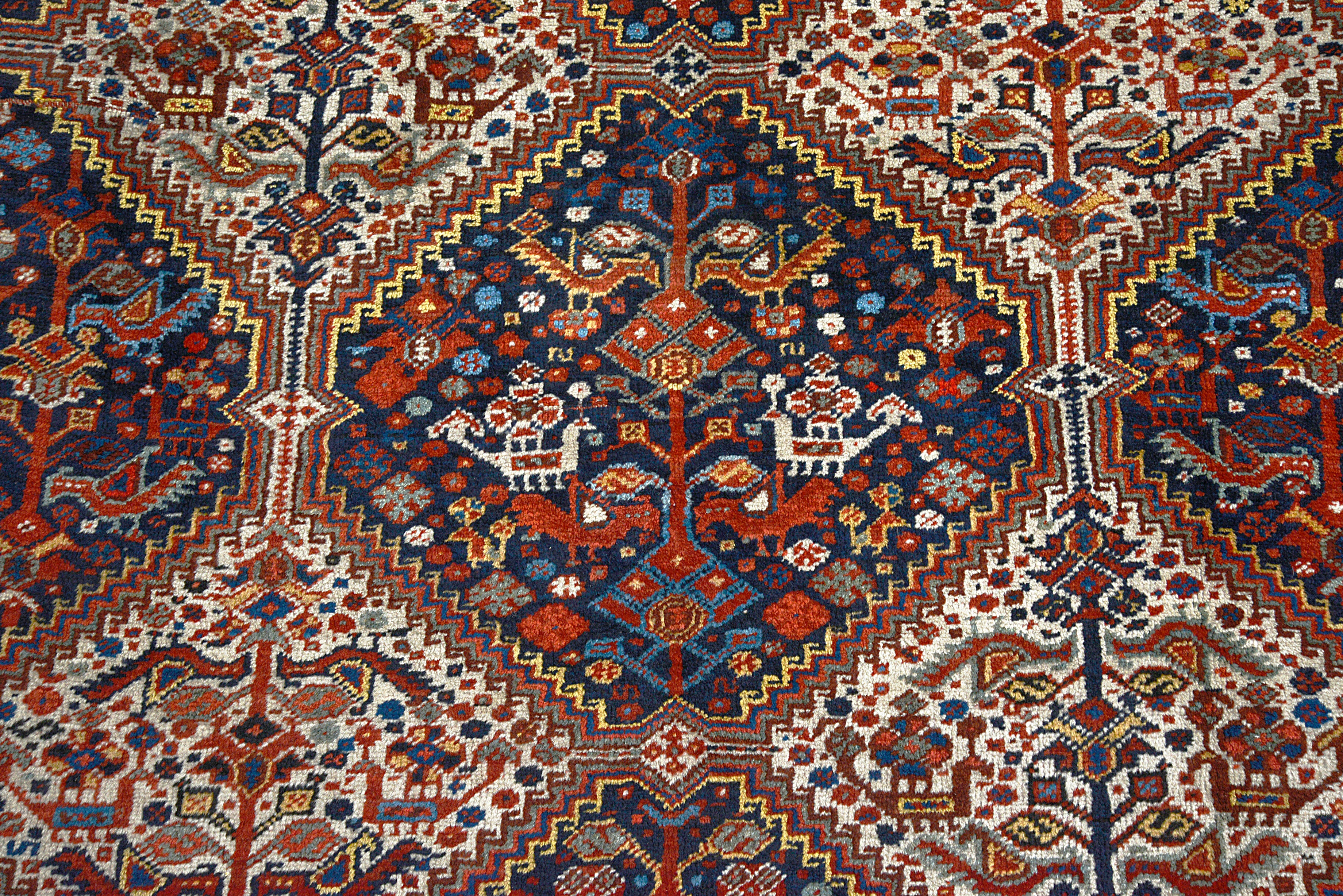 Close-up of repeating diamond motifs within the field of an antique Persian Qashqai carpet
