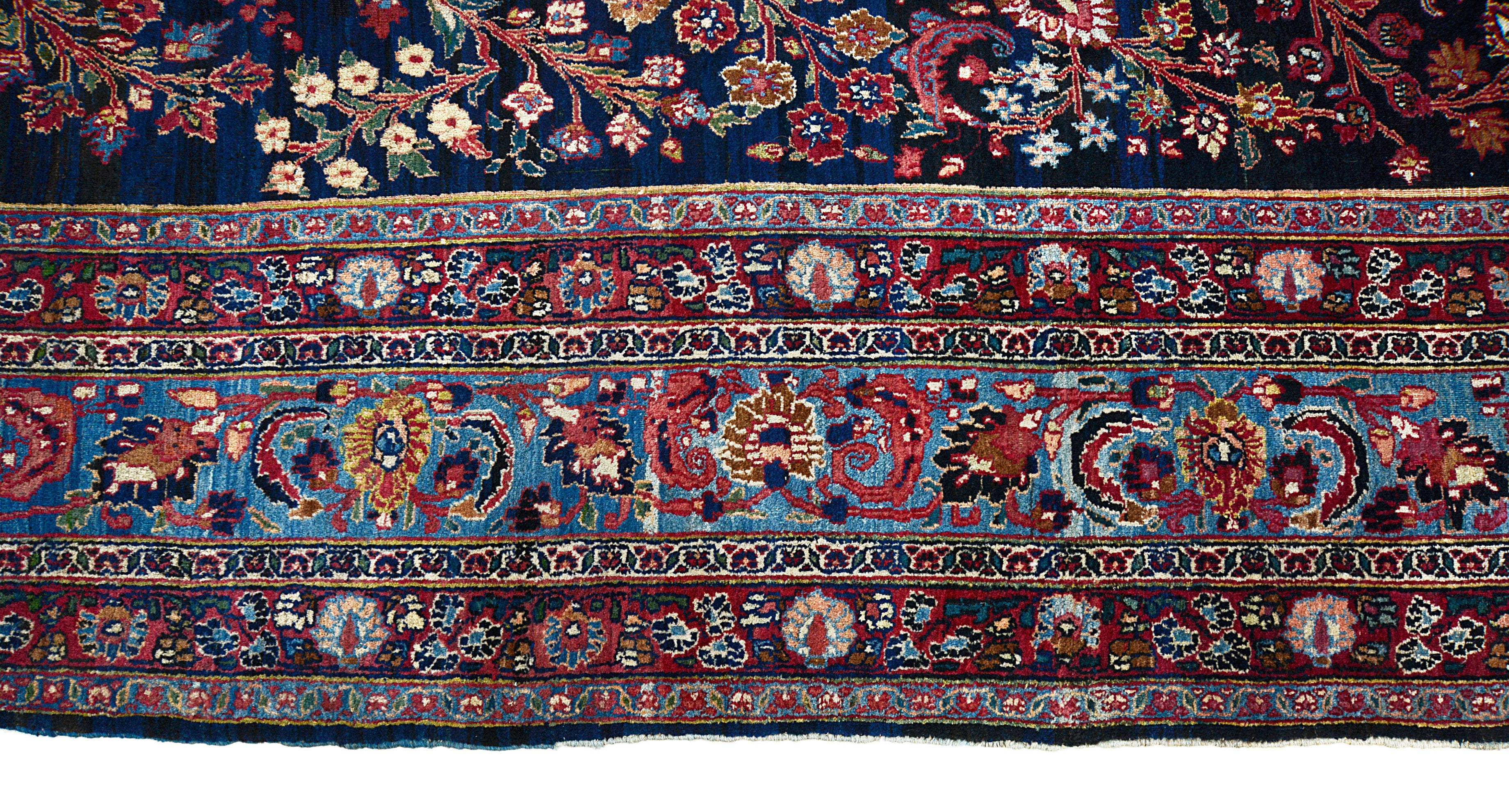 Border detail of an antique Persian Mashhad carpet with finely drawn floral motifs

